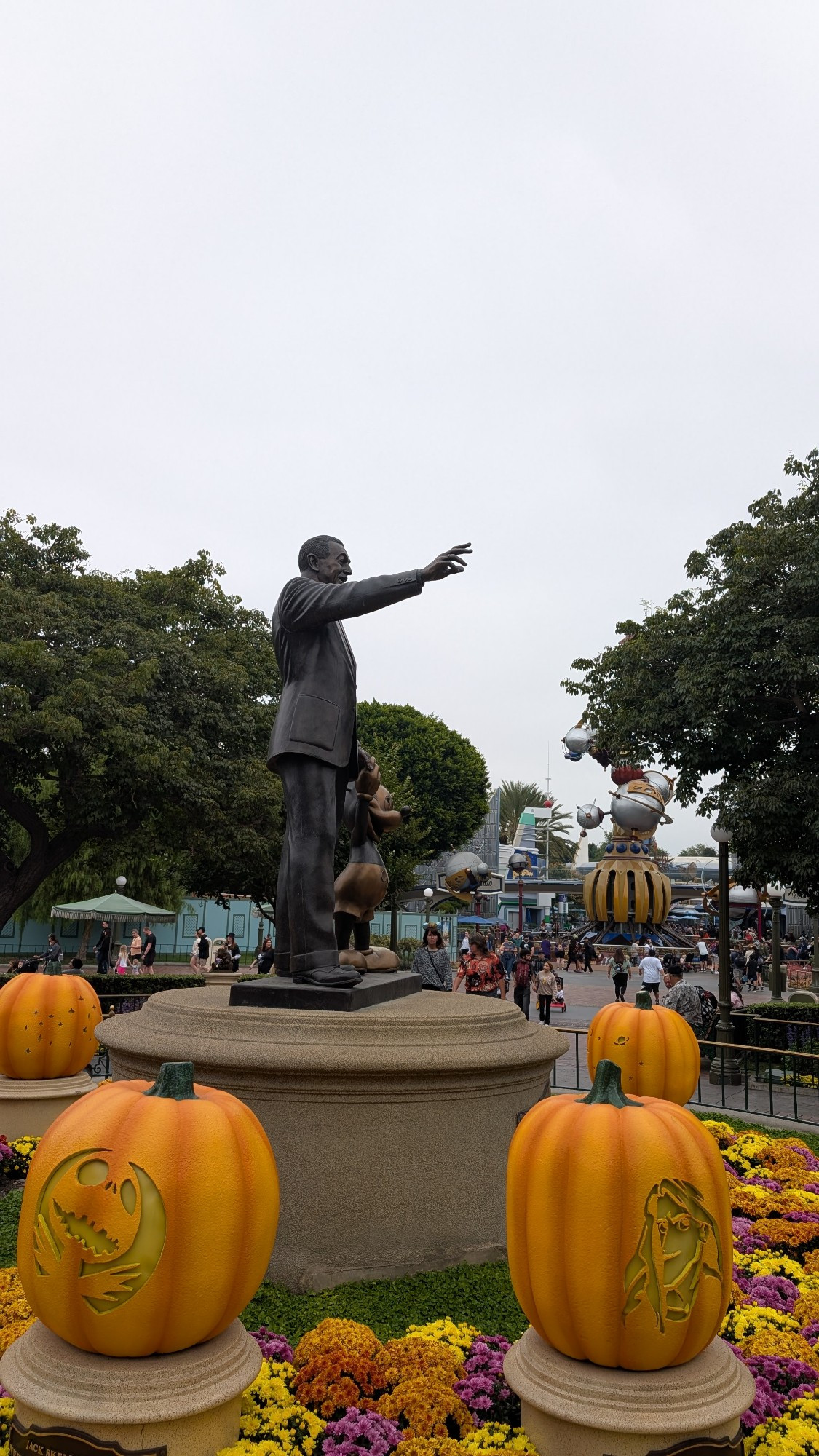 The statue of Walt Disney and Mickey surrounded by pumpkins carved like Disney characters 