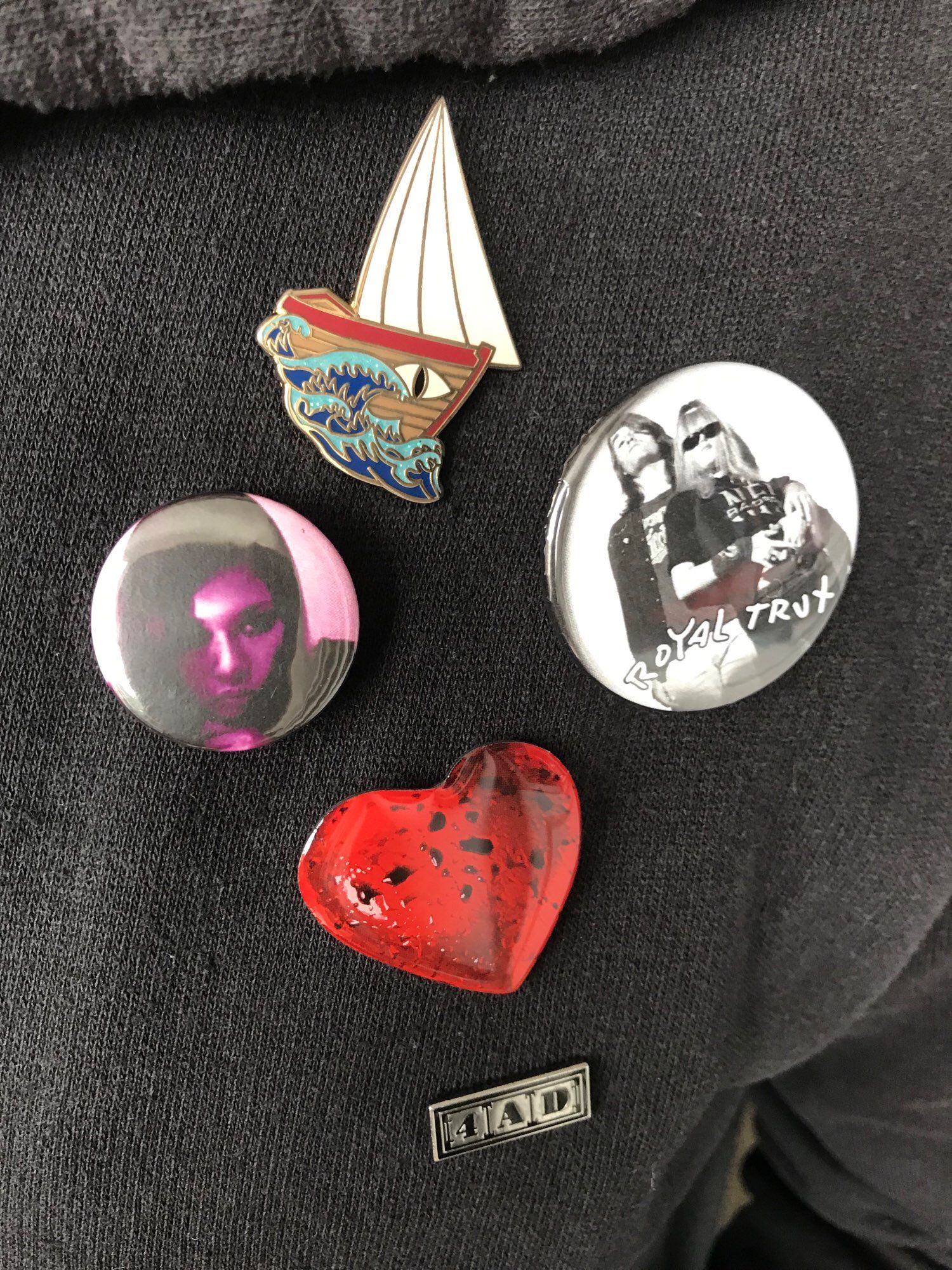 Badges for Ursula K Le Guin, Izumi Suzuki, The Breeders, Royal Trux and 4AD on a black hoodie