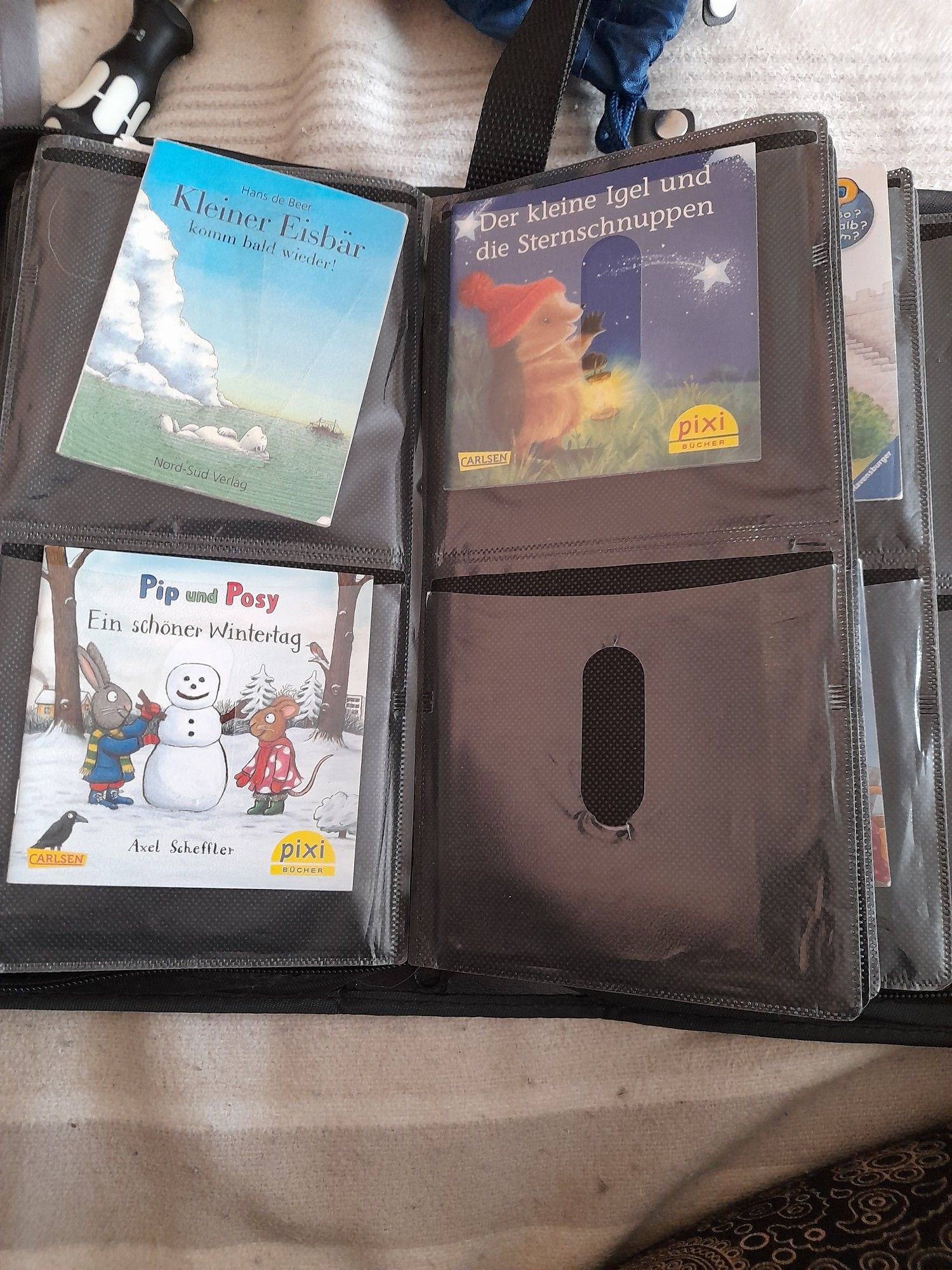 Eine alte Sammelmappe für CDs. In jedem Fach steckt ein Pixi Buch