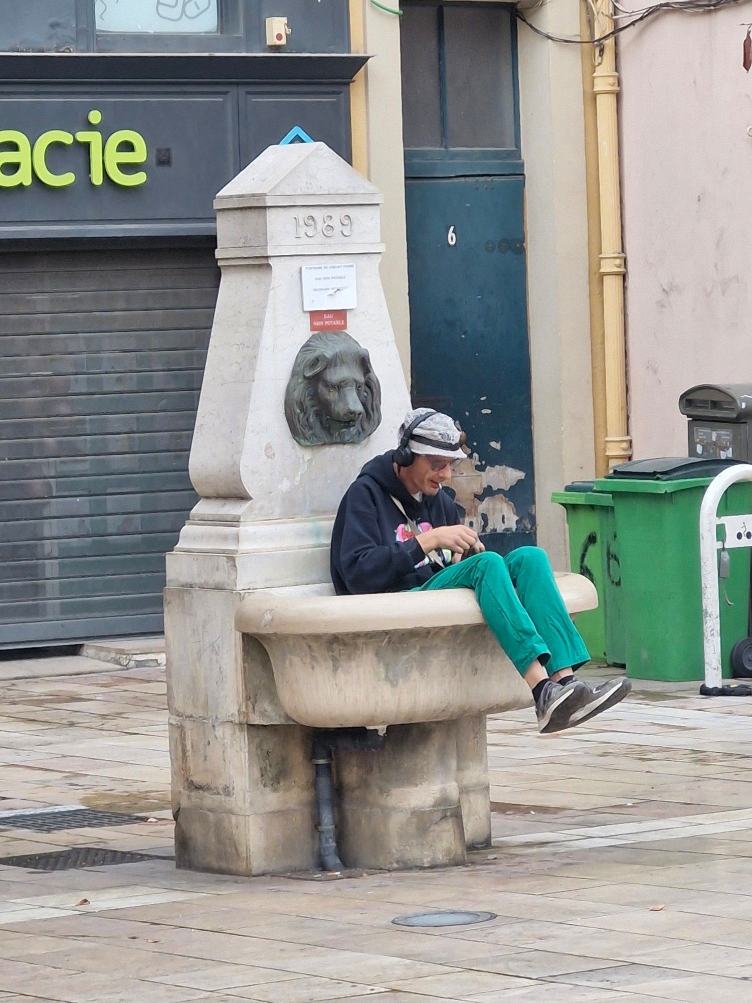 A man sitting in a water fountain basin.