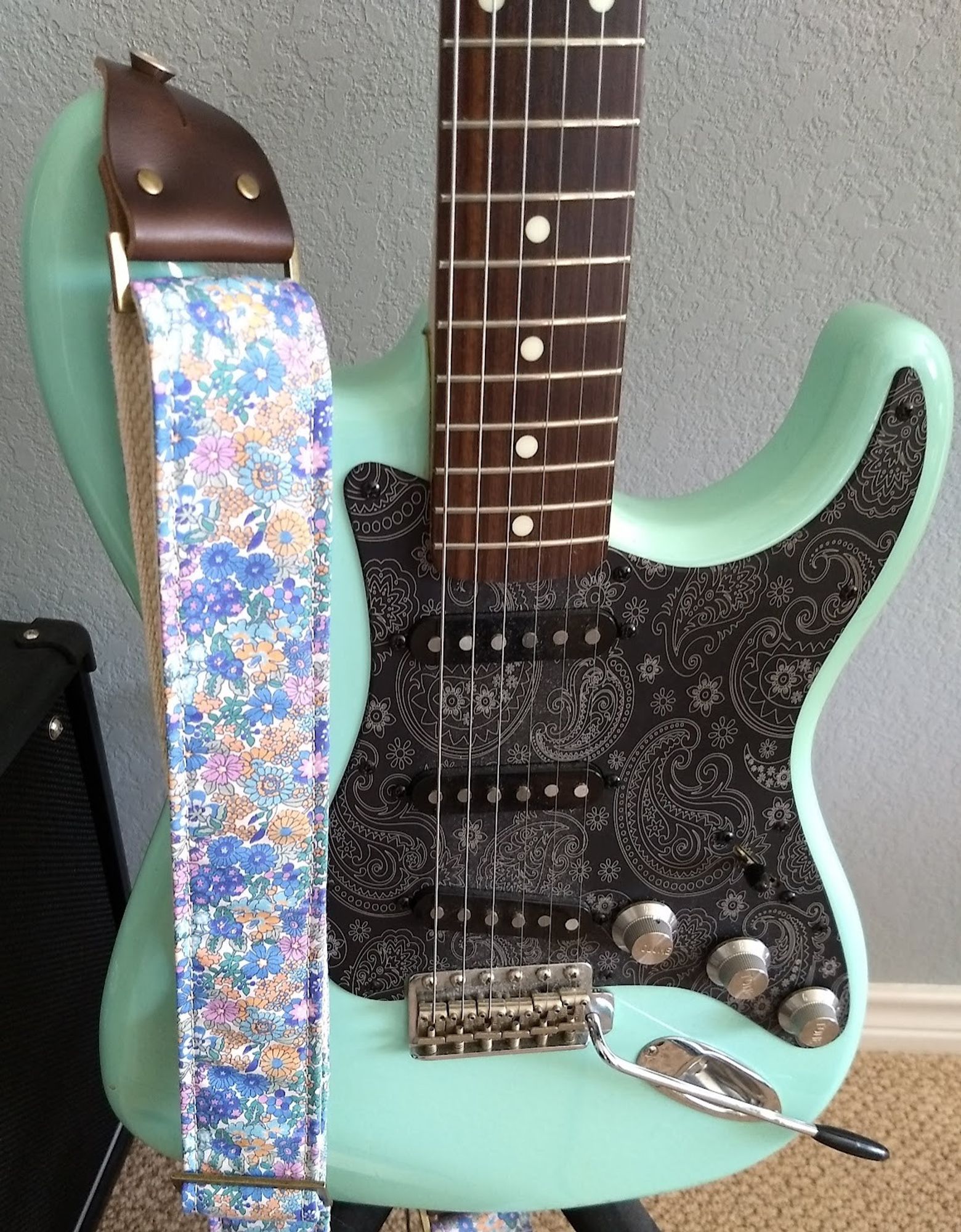 This is a 1962 Reissue Stratocaster made in Japan in 1990. I upgraded the wiring, capacitors, and potentiometers about 15 years ago. The pickguard is matte black aluminum with silver paisley designs. I also updated the knobs to stainless steel knobs about 5 years ago.  The polyurethane coat has yellowed so that the Sonic blue now looks a little more like seafoam green.