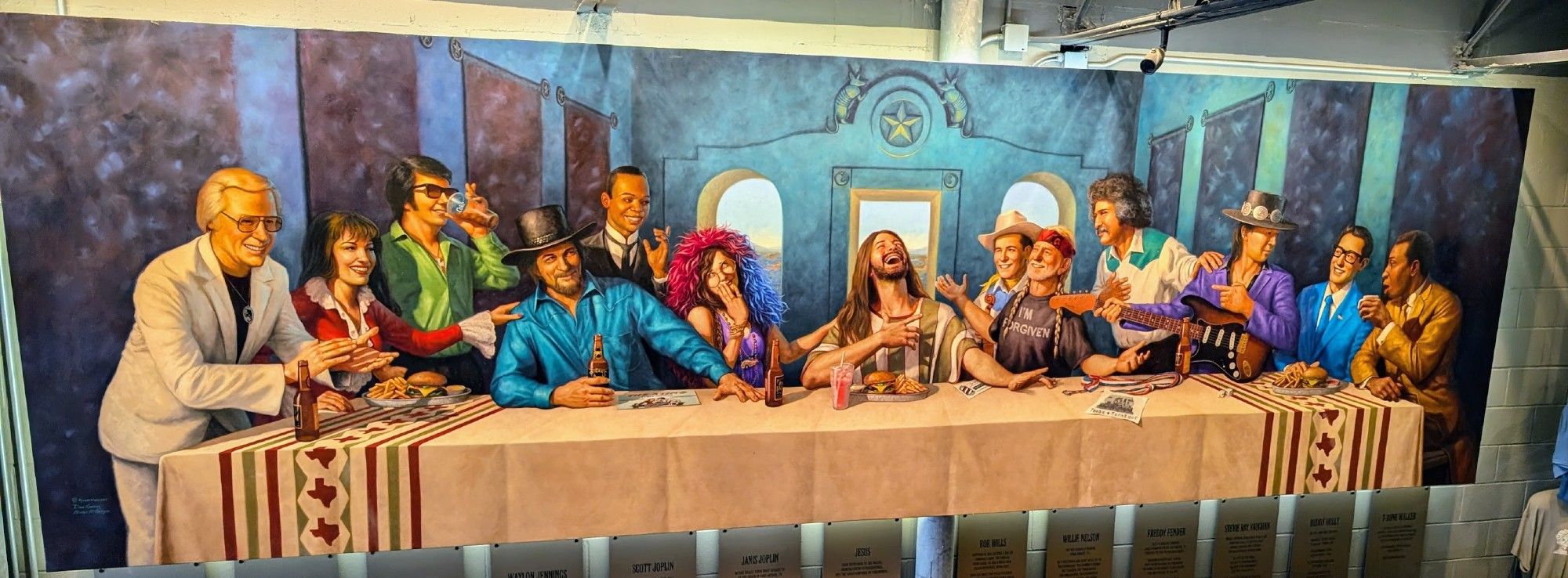 A mural in the style of the Last Supper with Texas musicians of all genres. From left to right: George Jones, Selena, Roy Orbison, Waylon Jennings, Scott Joplin, Janis Joplin, Jesus (not a Texan), Bob Wills, Willie Nelson, Freddie Fender, Stevie Ray Vaughan, Buddy Holly, and T-Bone Walker.