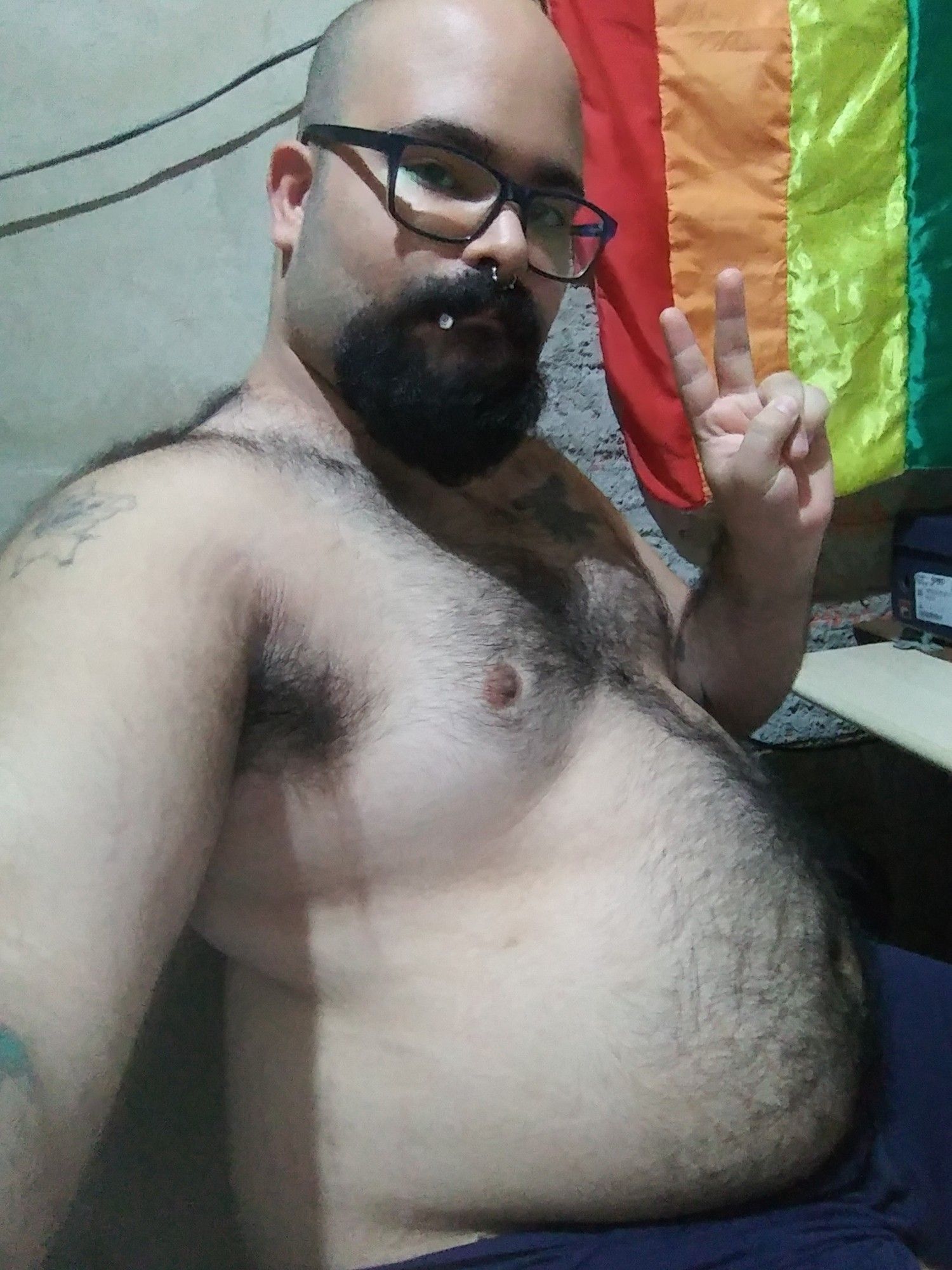 Homem sem camiseta, sentado, faz pose para a câmera