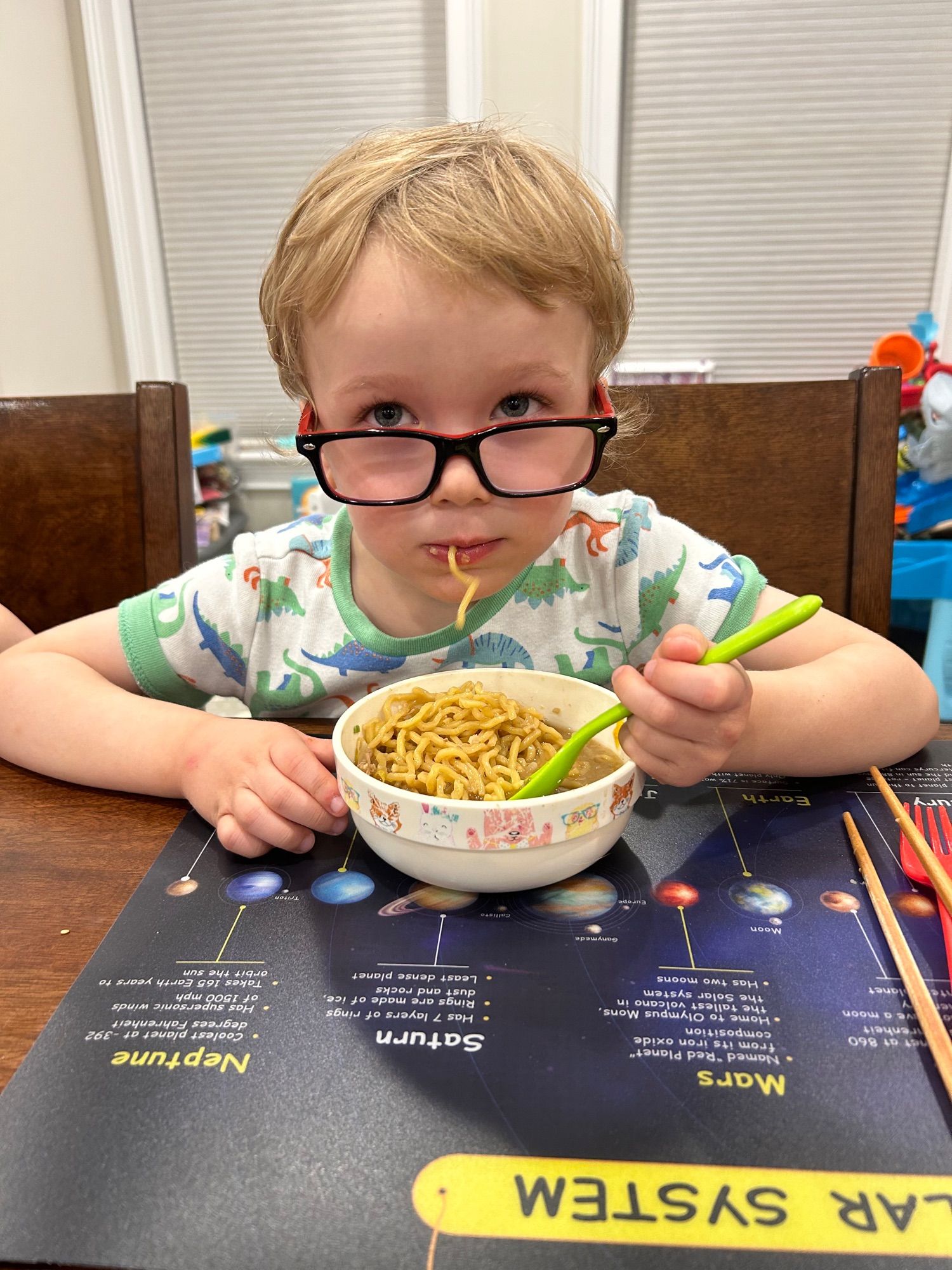 Child eating ramen while sporting new glasses