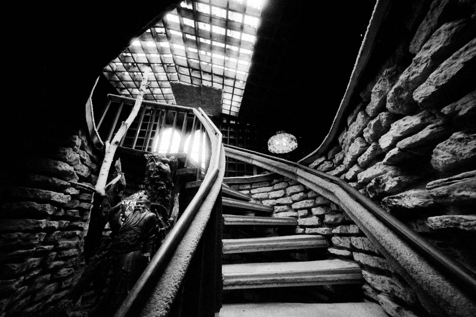 An ultrawide view of the elaborate stone staircase inside the earliest structure of The House on the Rock