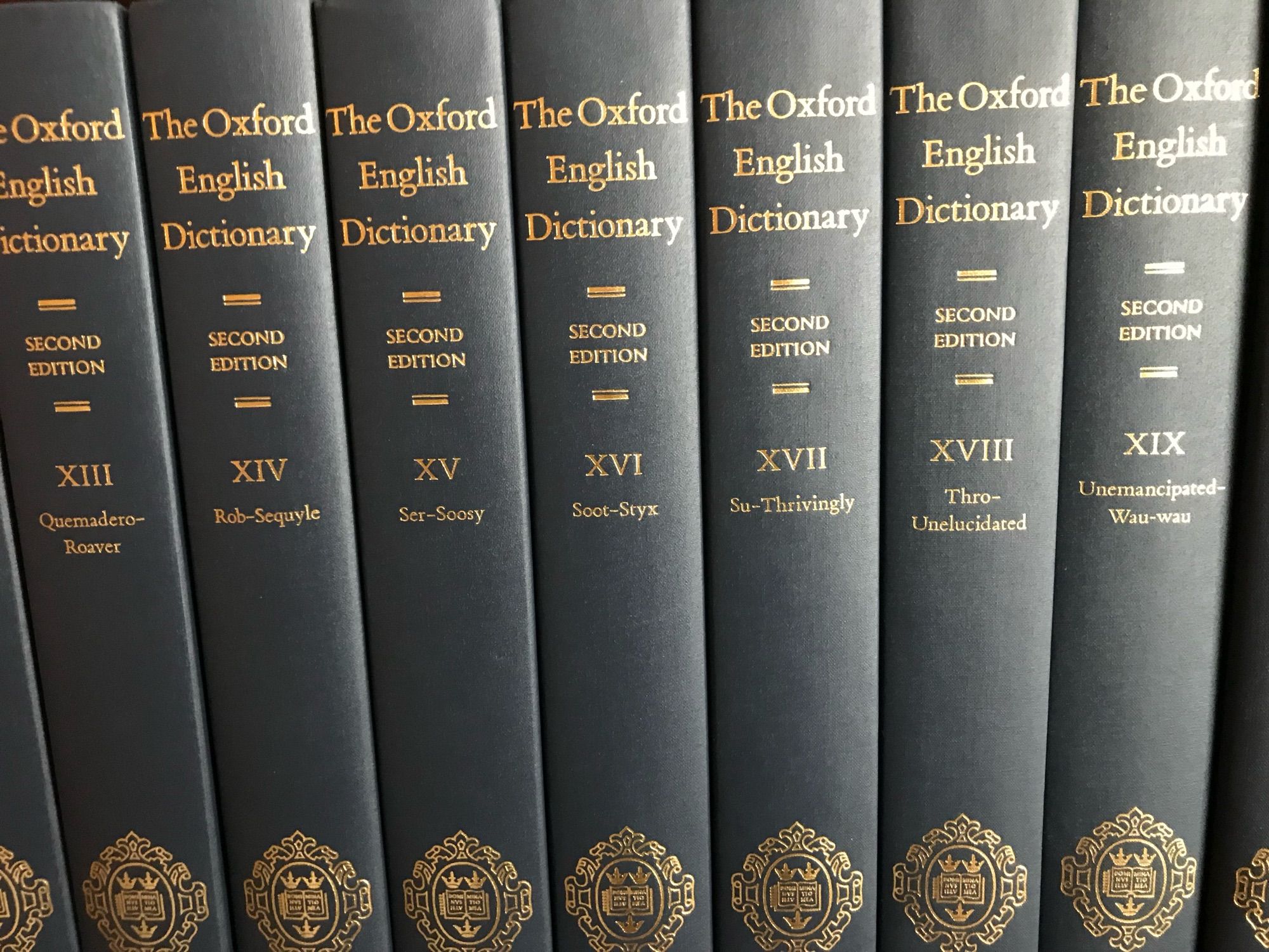 A shelf of many
volumes of Oxford English 
Dictionary, blue.