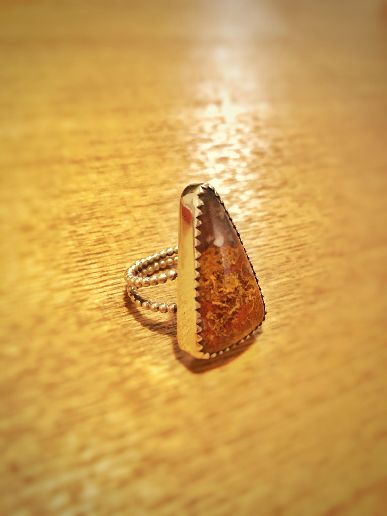 A silver triangle ring with an agate stone.