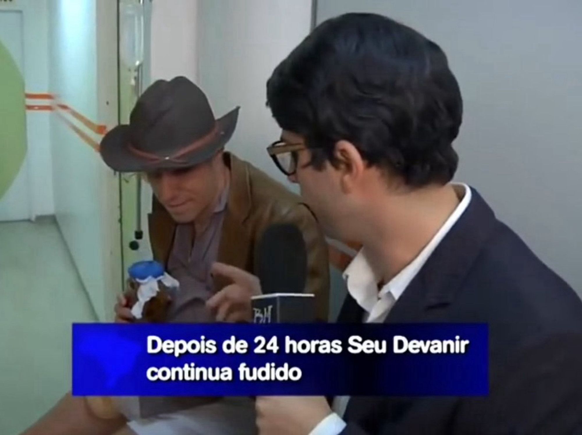 Cena de Hermes e Renato, homem sendo entrevistado em reportagem no hospital com o seguinte título na tela “Depois de 24 horas Seu Devanir continua fudido”