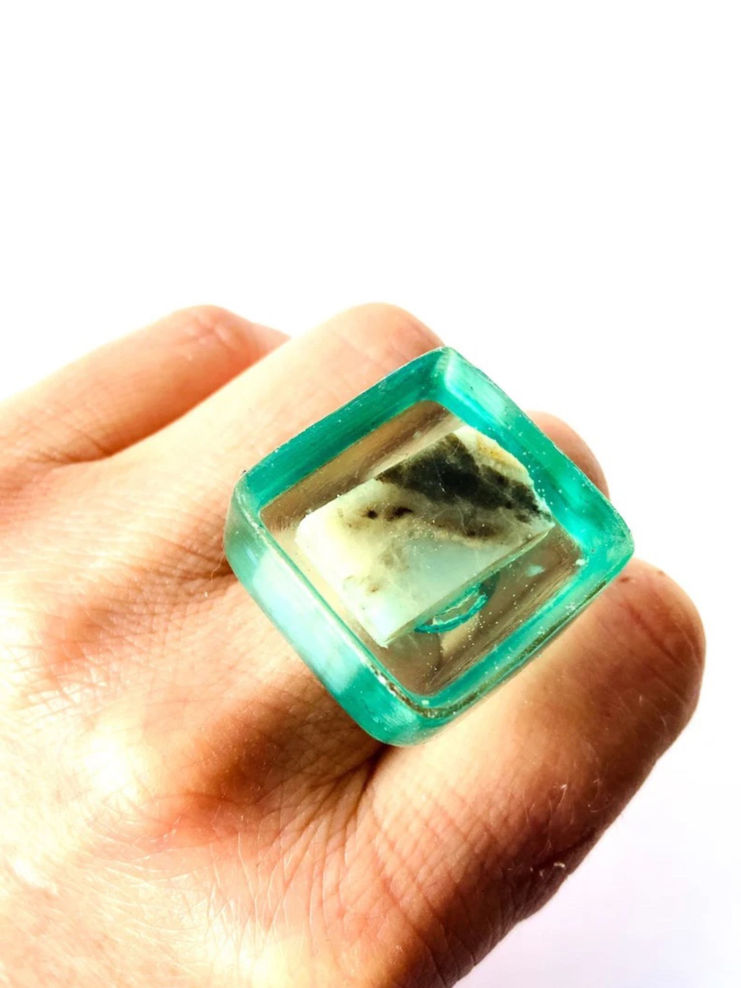 Ring with square cube of clear aqua resin with multicolored piece of natural stone in it