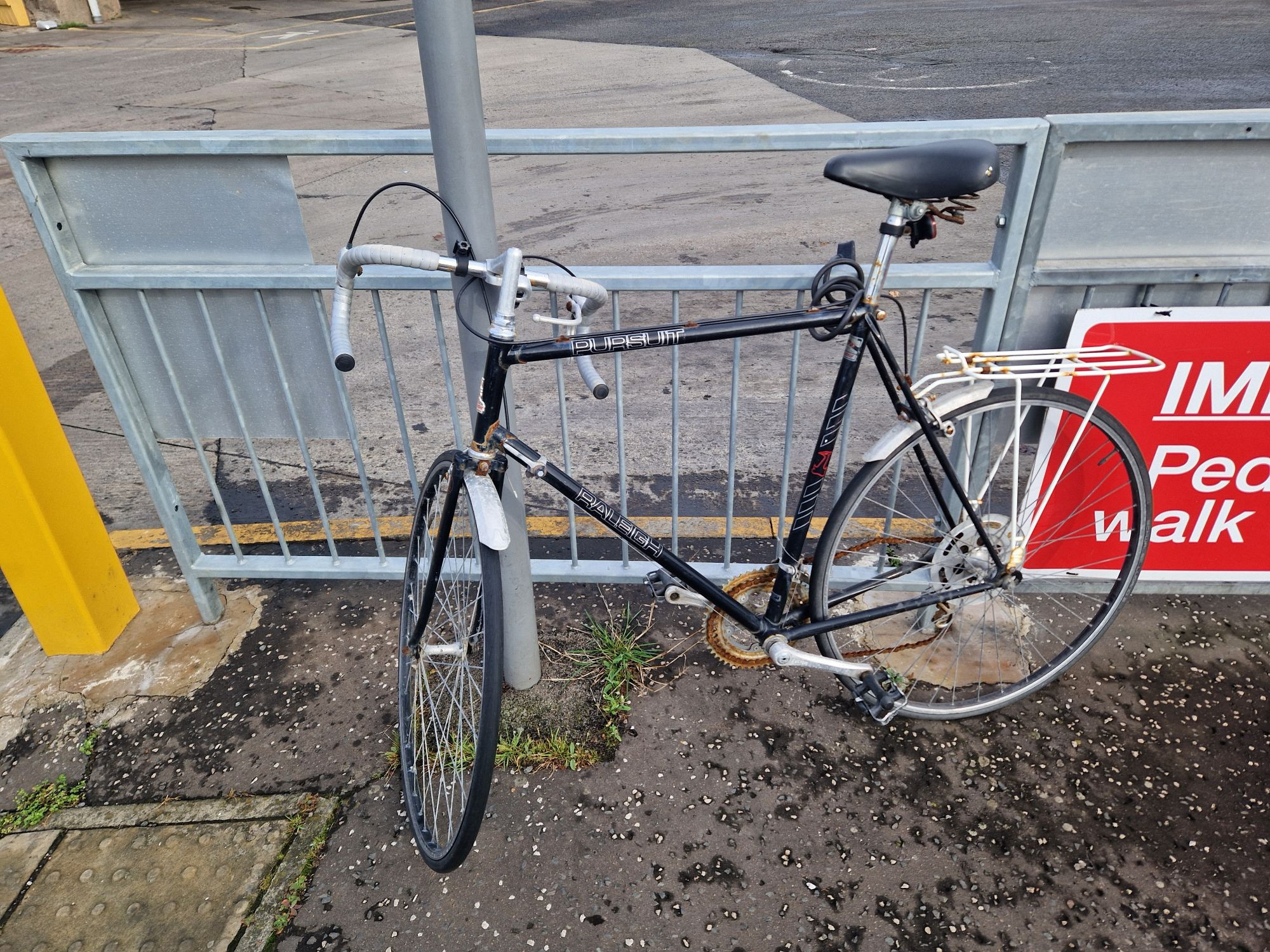 Vintage Raleigh Persuit Bicycle with a very rusty chain sitting outside St Andrews bus station.