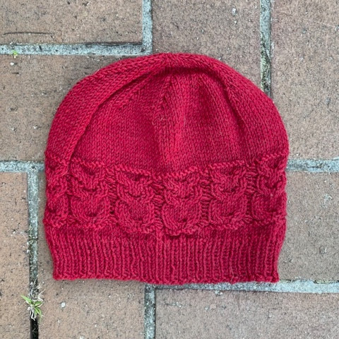 Red beanie with cable knit owls worked into it