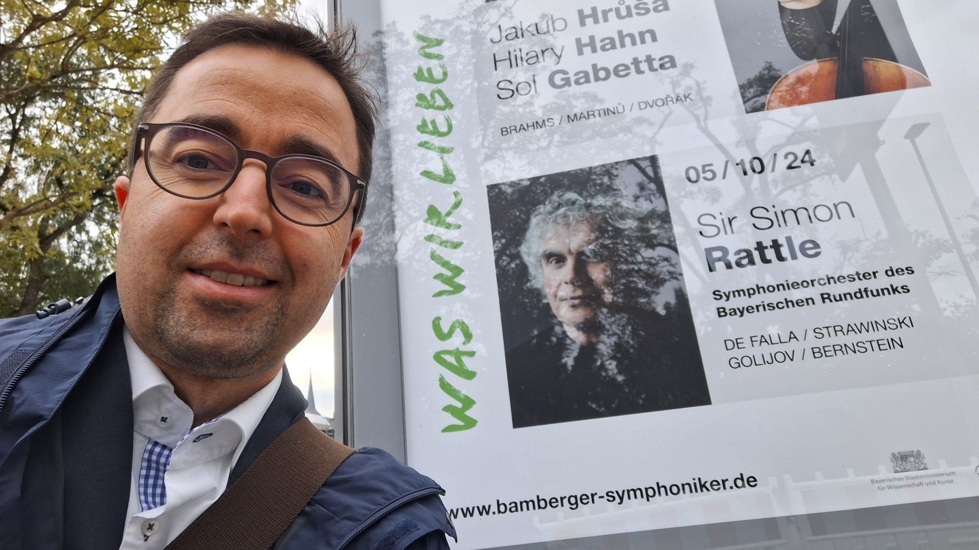 Selfie (ich links) vor dem Konzertplakat (rechts) für heute Abend im Bamberger Keilberth-Saal, auf dem Plakat Sir Simon Rattle. Er dirigiert heute das Symphonieorchester des BR.