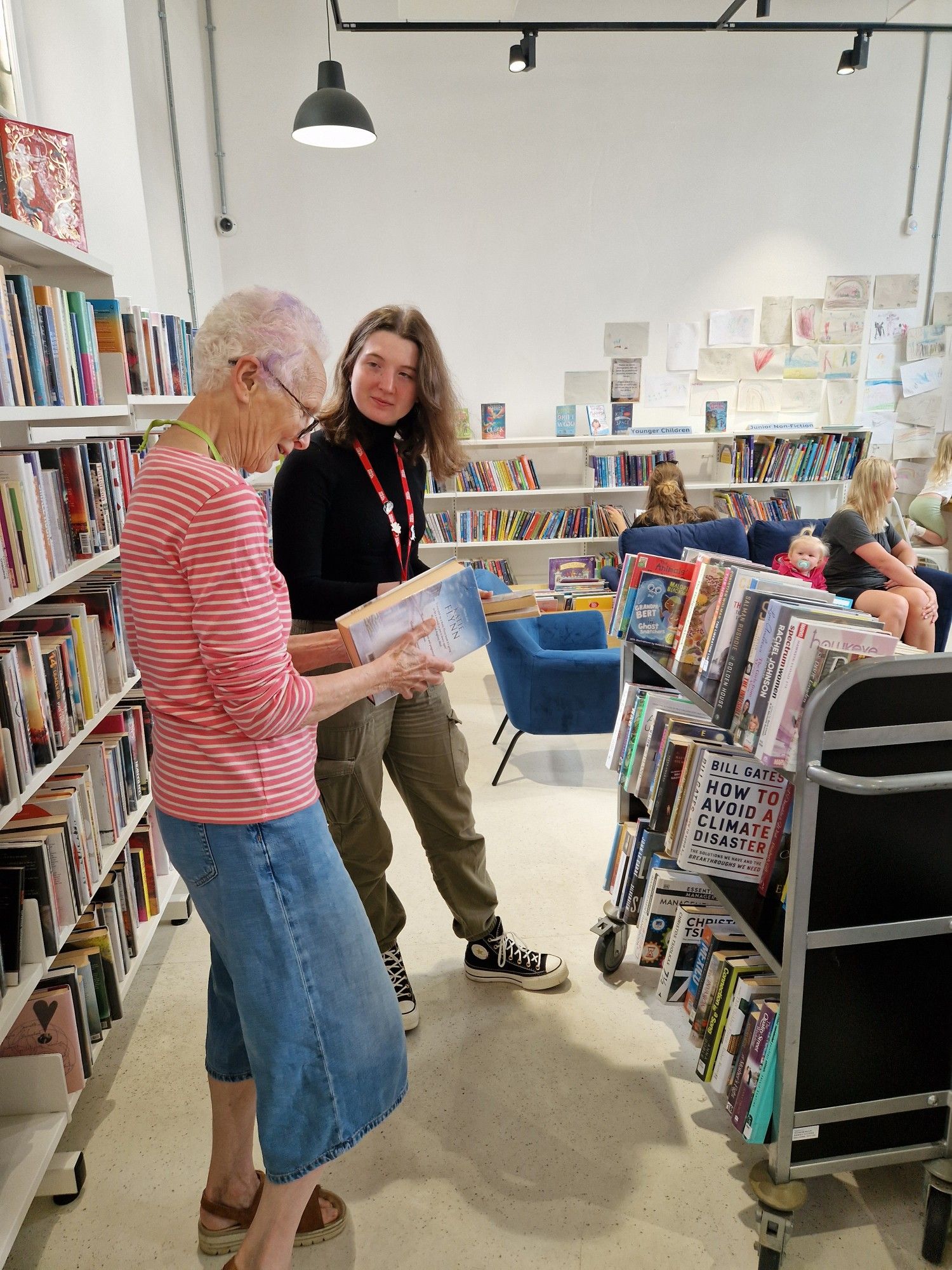 People looking through the books at Liskeard Library. Credit - Real Ideas Organisation.