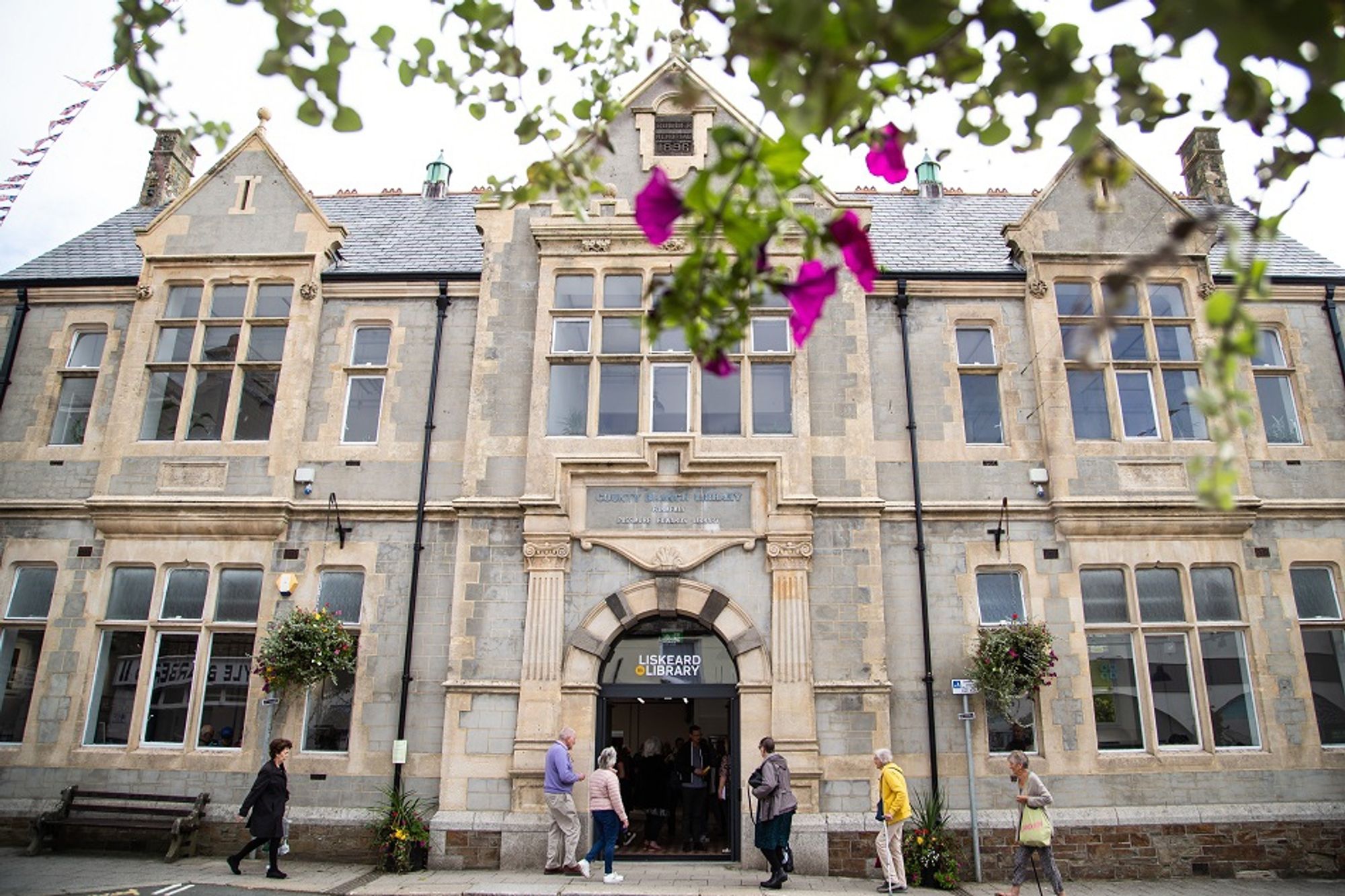 The exterior of Liskeard Library. People are seen walking through the entrance. Photo by Sean Hurlock.