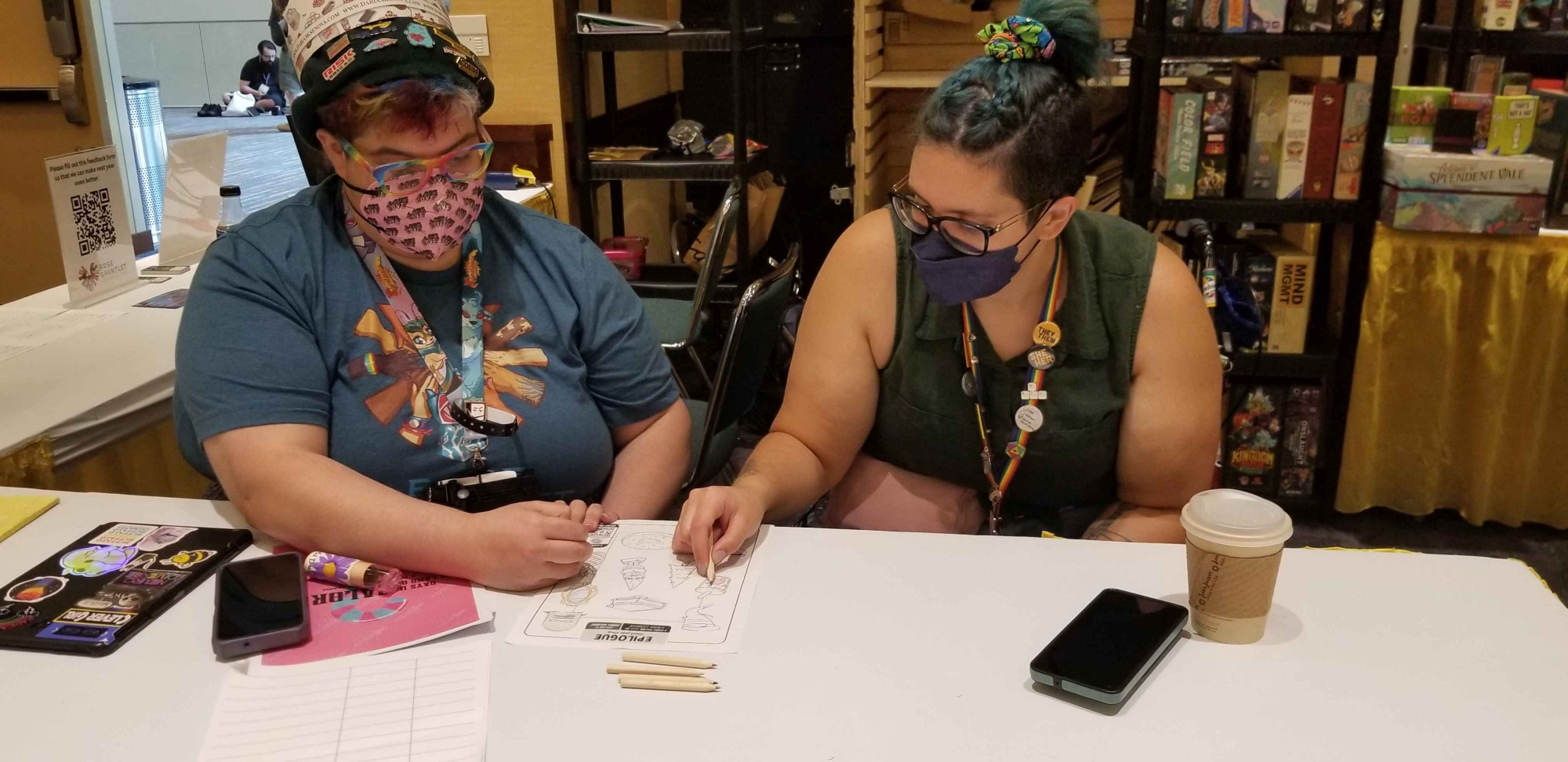 Rina and Maria coloring together at the BIPOC lounge at Gen Con 2024.