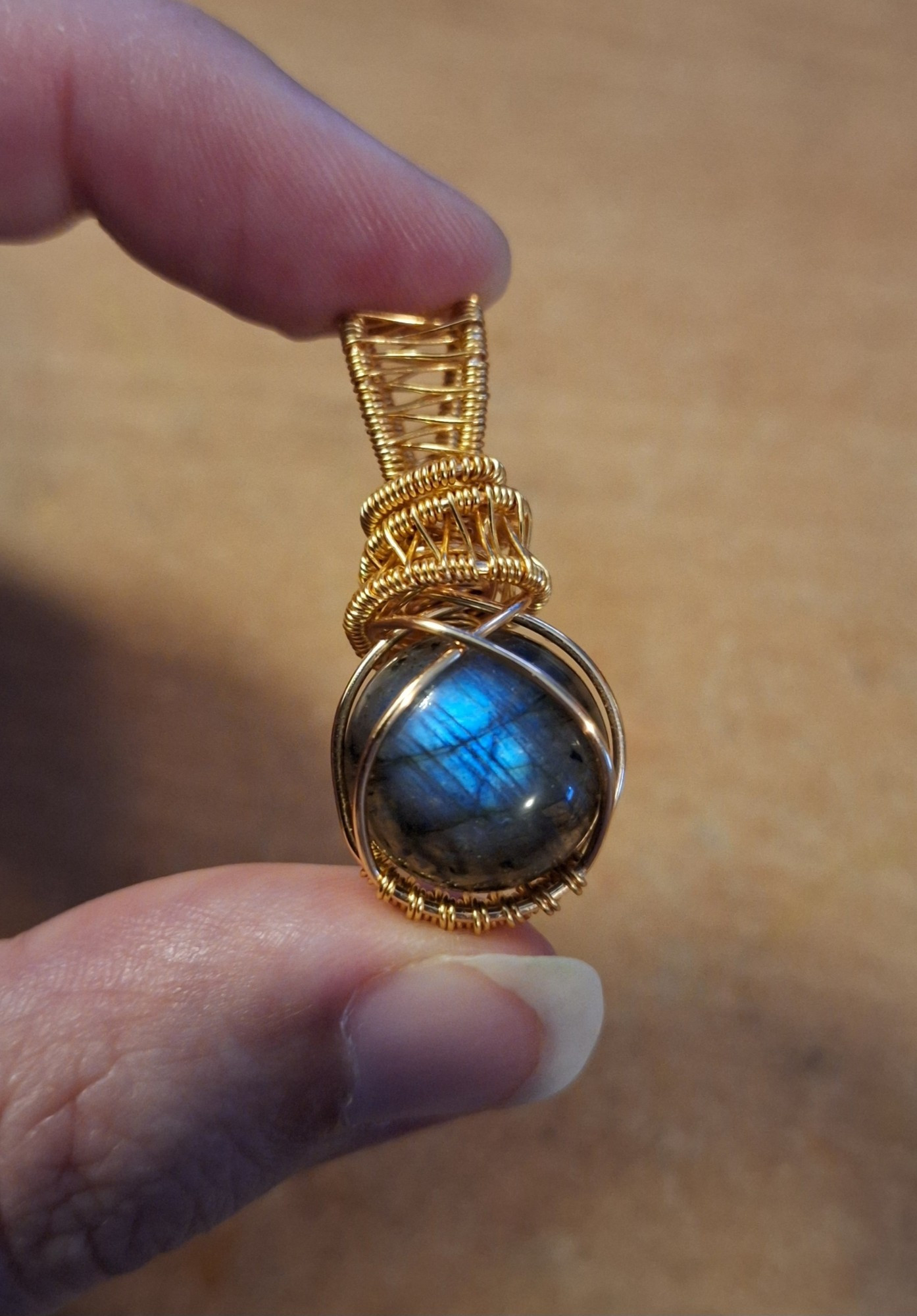 Round labradorite cabuchon with a blue flash wirewrapped with round gold wire