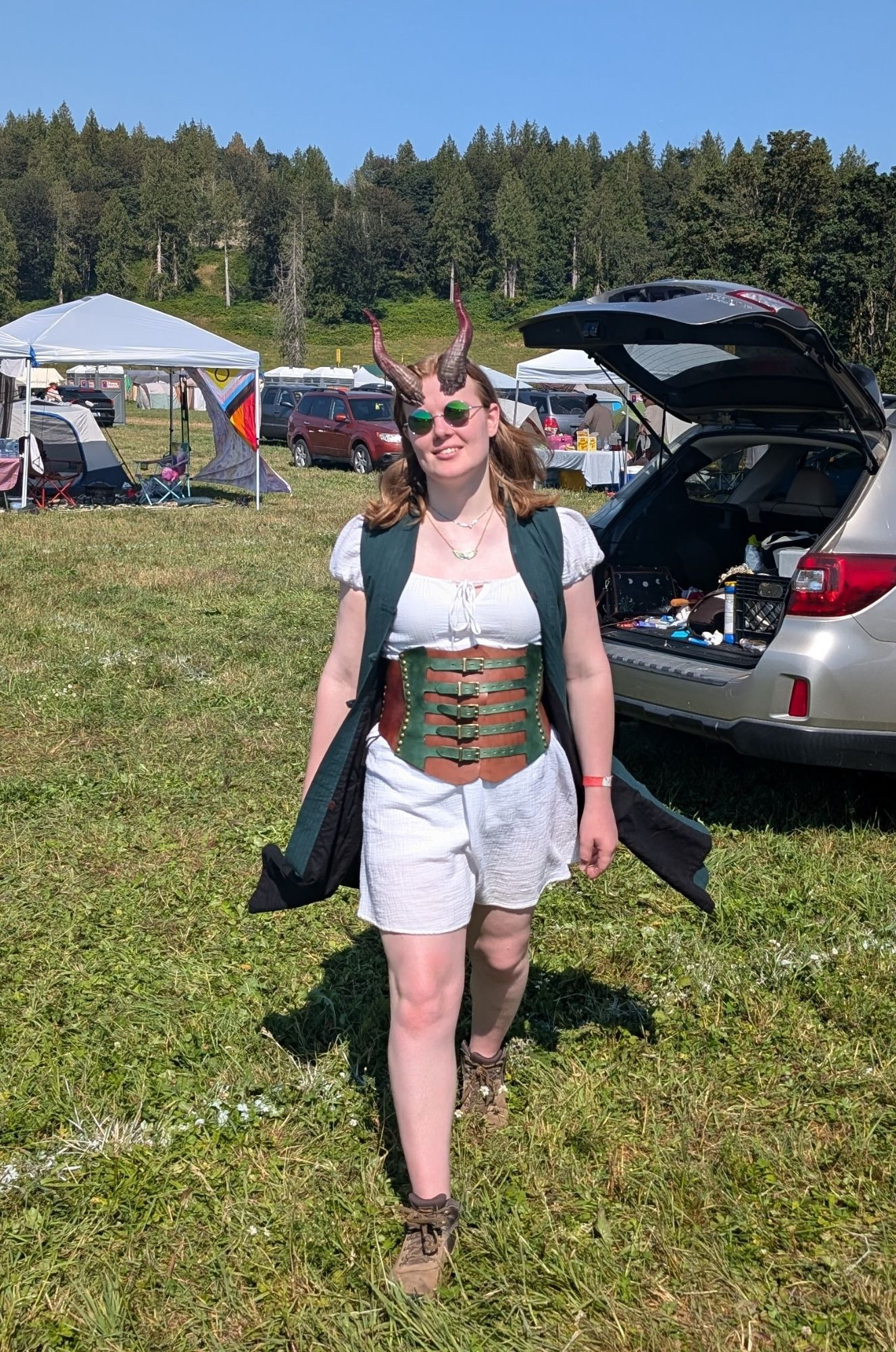 Abby with tiefling/devil horns and round green mirror sunglasses, striding menacingly towards the camera