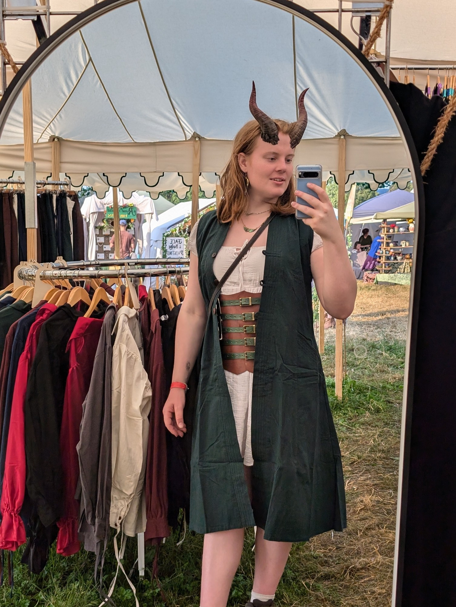 Abby with tiefling/devil horns, posing in a long green vest