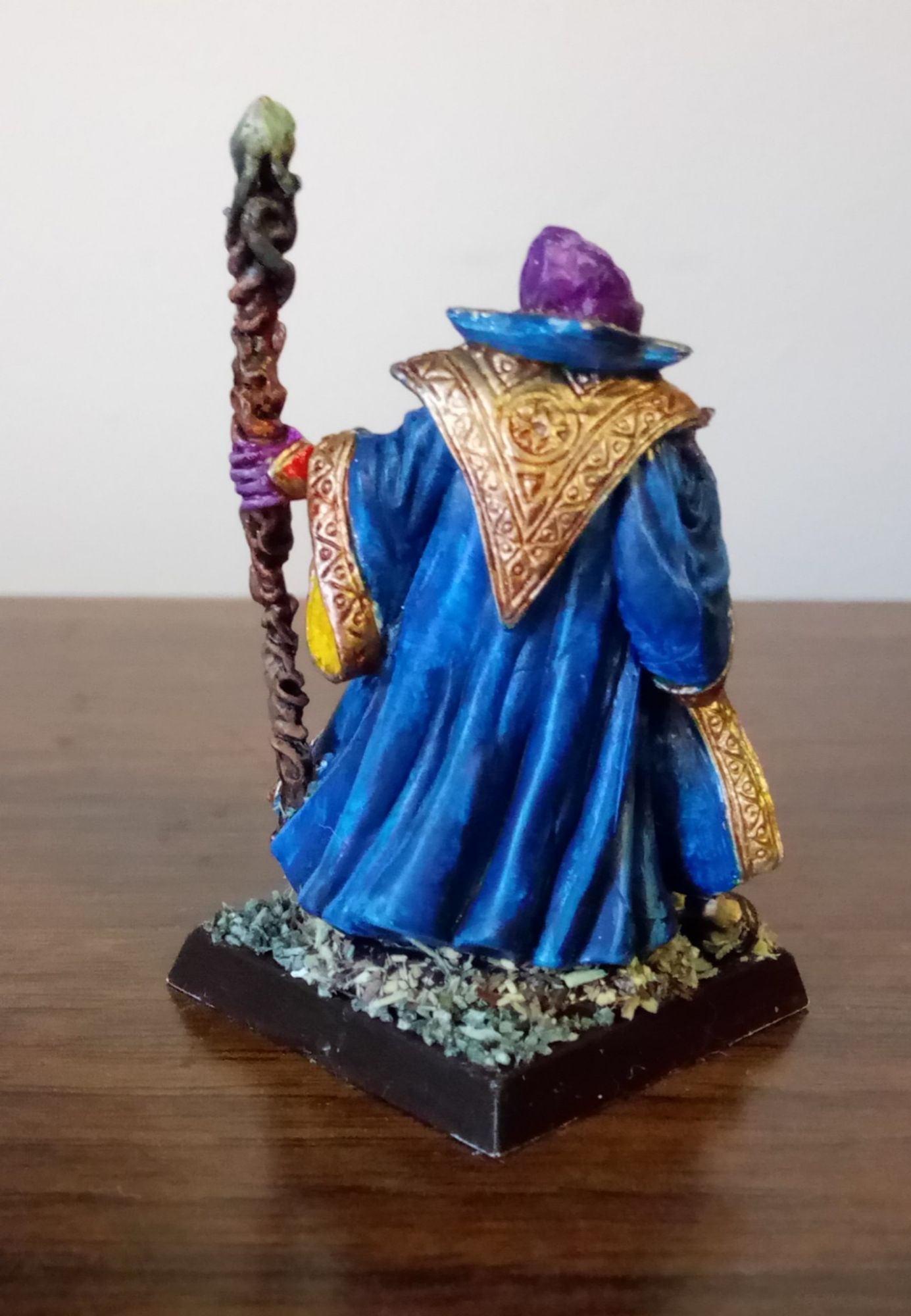 Back of the Mindflayer.  The blue robe has a large golden triangle with arcane patterns hanging upside down from the neck.