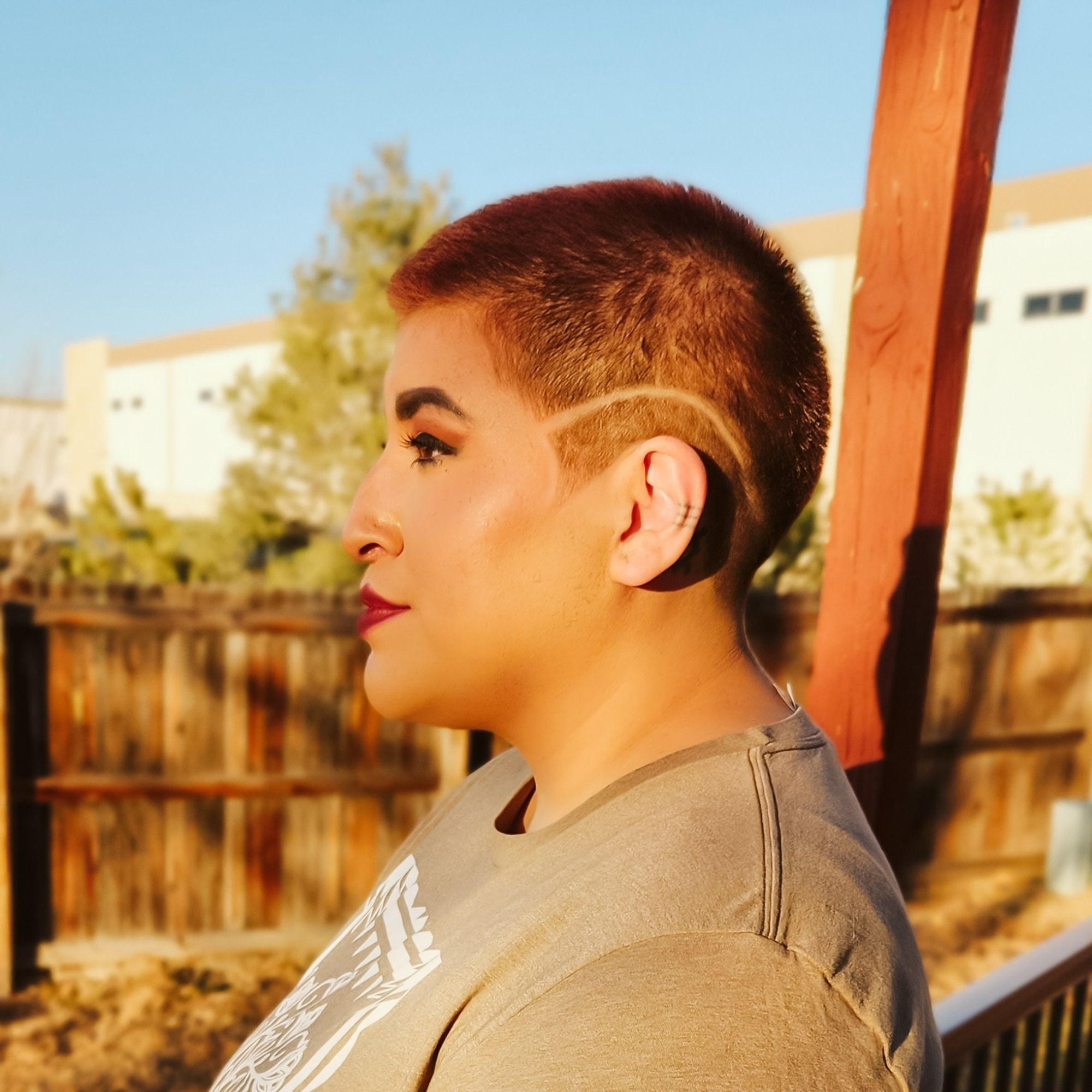 Dr. BlackDeer profile outside in sunset glow with a freshly shaved head