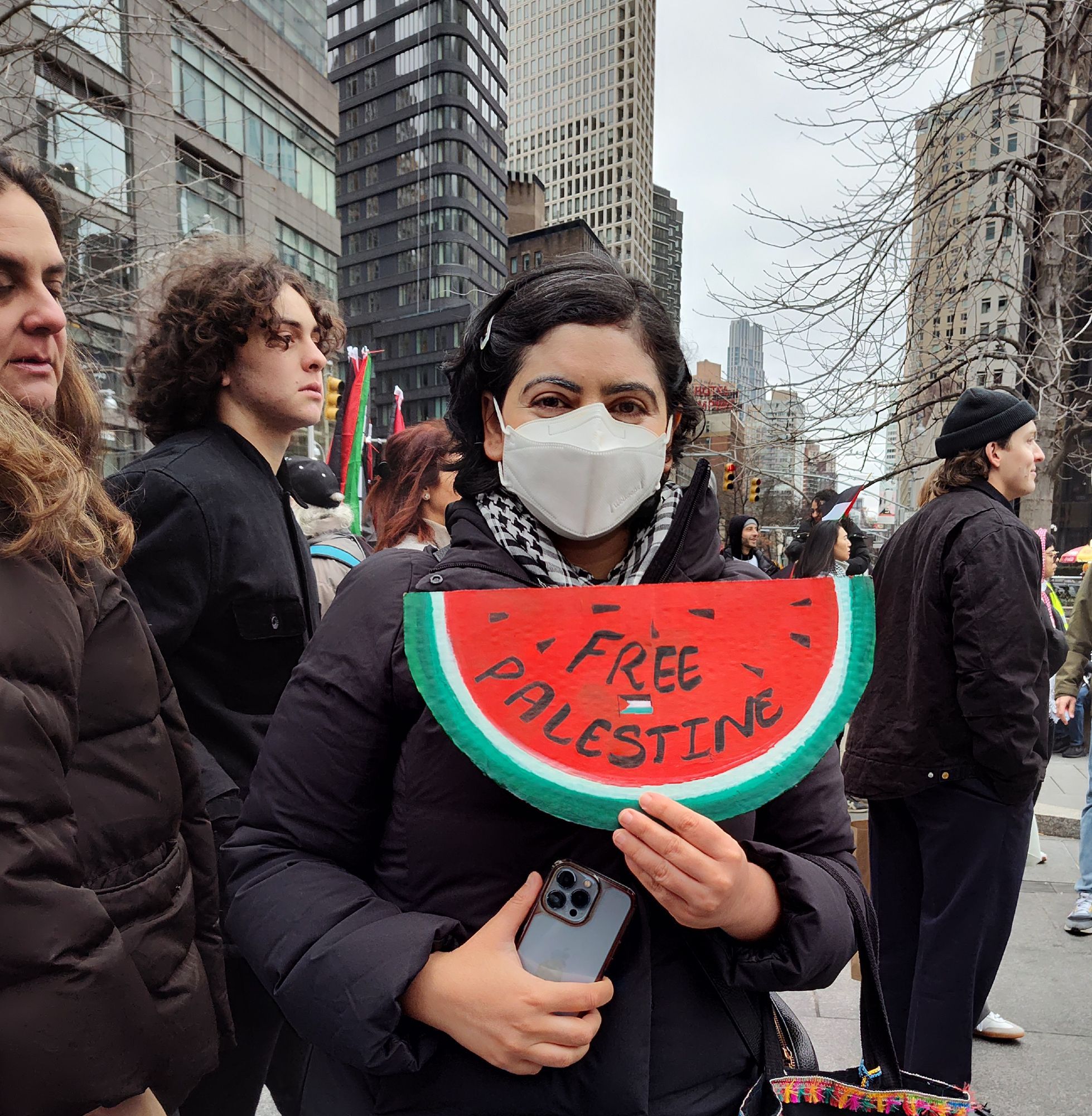 An activist outside of a pro-Palestine rally in NYC is holding up a handmade symbol of watermelon and it reads free Palestine