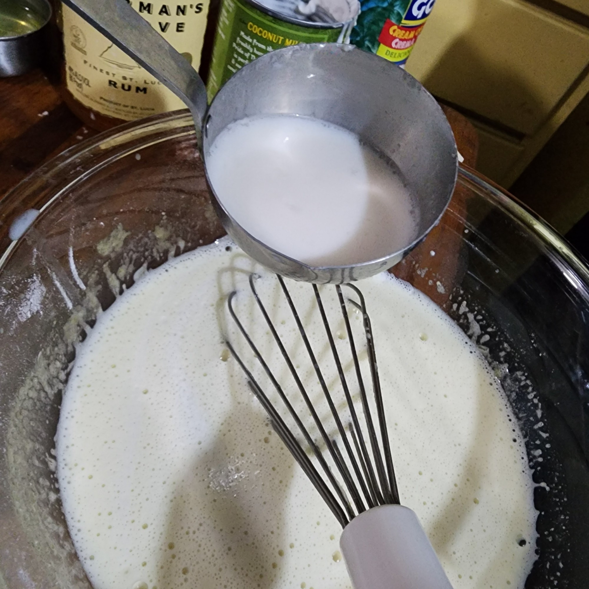 slowly drizzling the hot milk into the egg, whisking the whole time, to temper the wgg