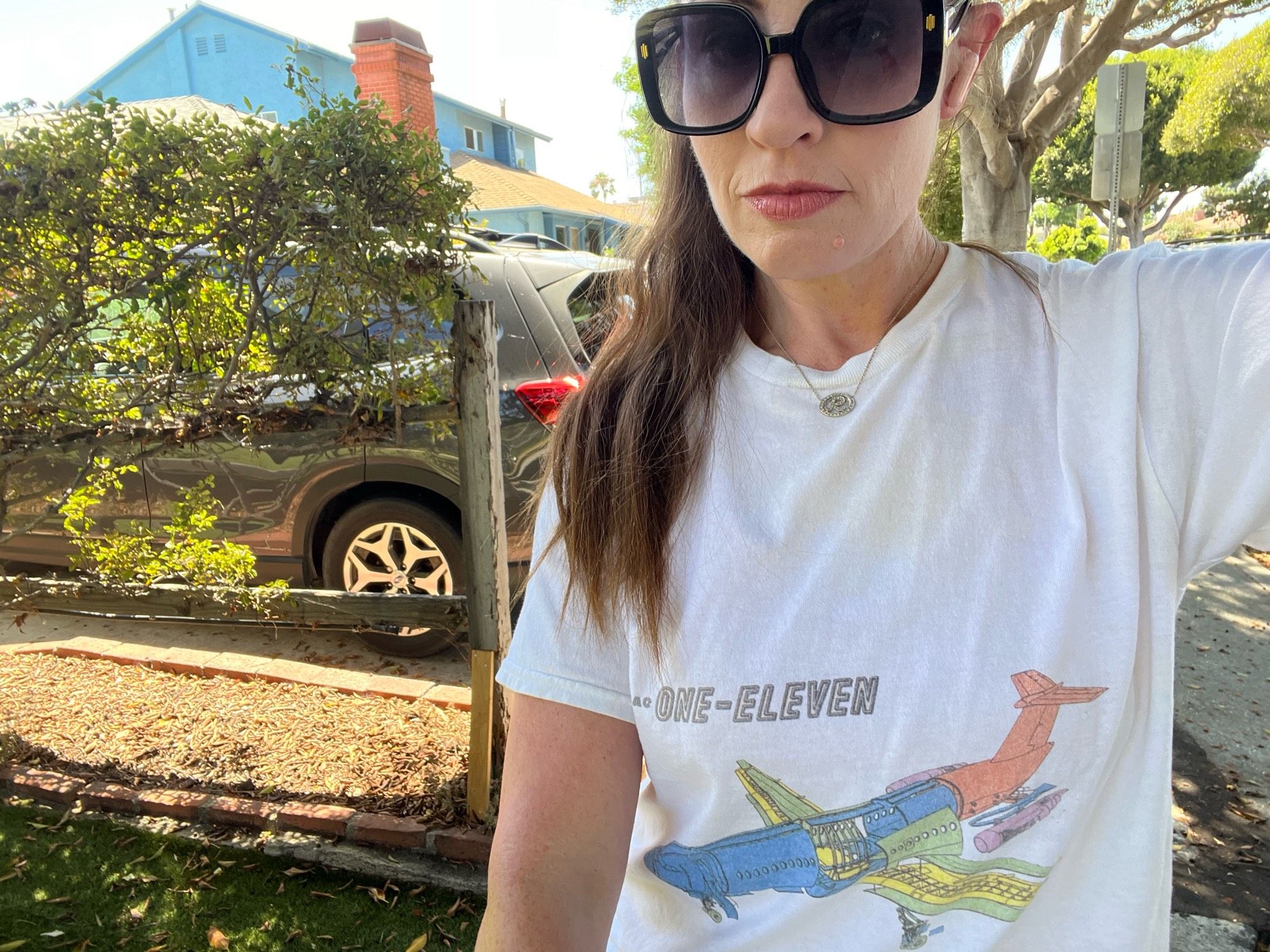 Woman wearing white tee with plane on it