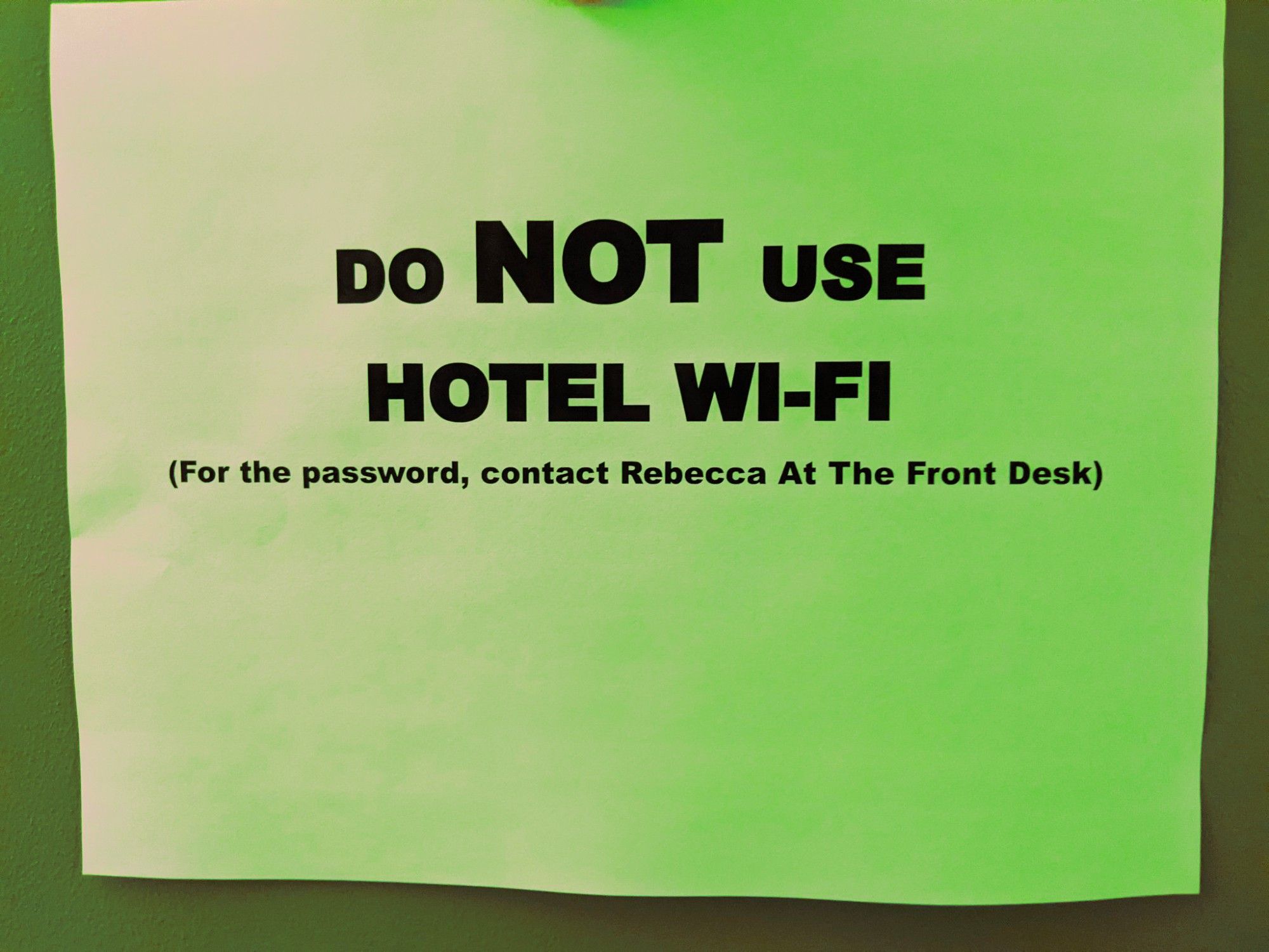 A sign that says "DO NOT USE HOTEL WI-FI (For the password, contact Rebecca At The Front Desk)"