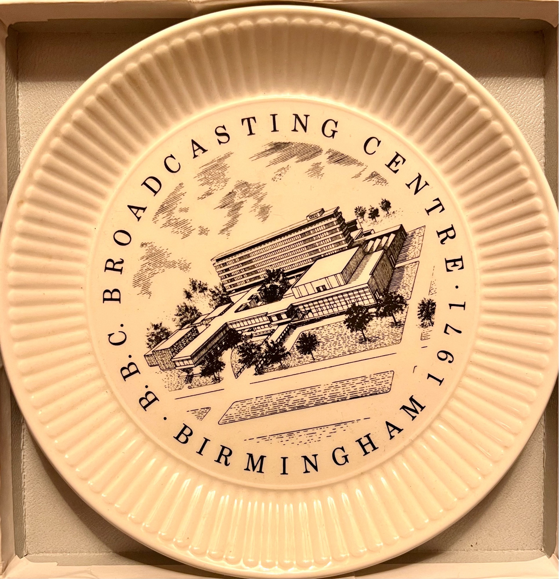 A white plate with a black architectural drawing of bbc Birmingham on it