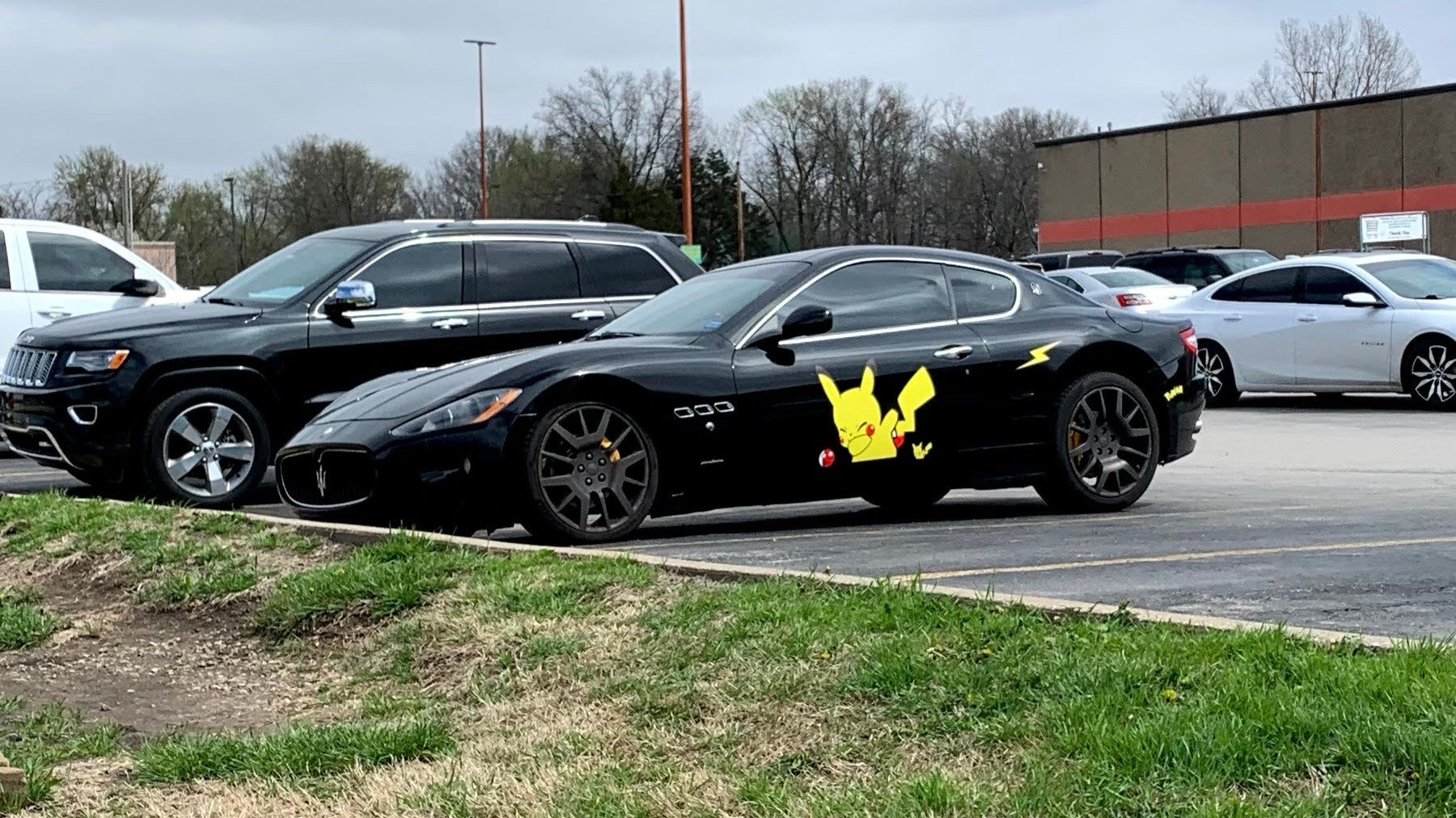 A black Maserati with a large pikachu decal on the driver door