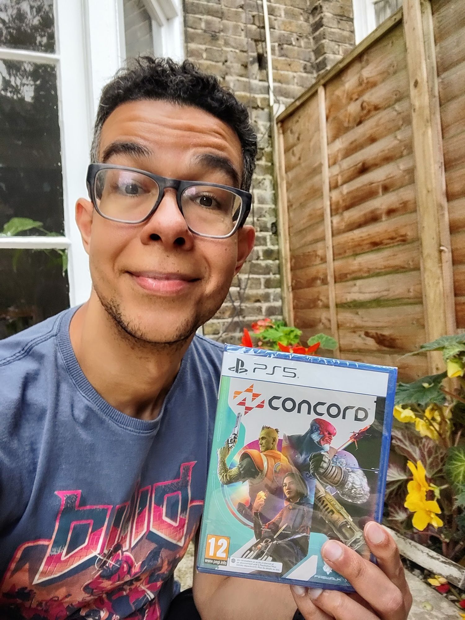 Happy dude in the garden, holding his Concord for PS5 physical media