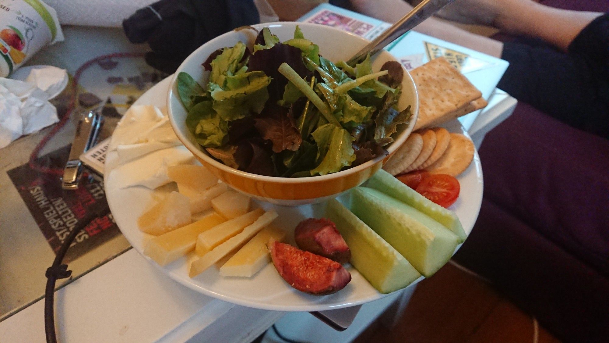 a plate with cheeses, crackers, vegetables, fruit and salad on it