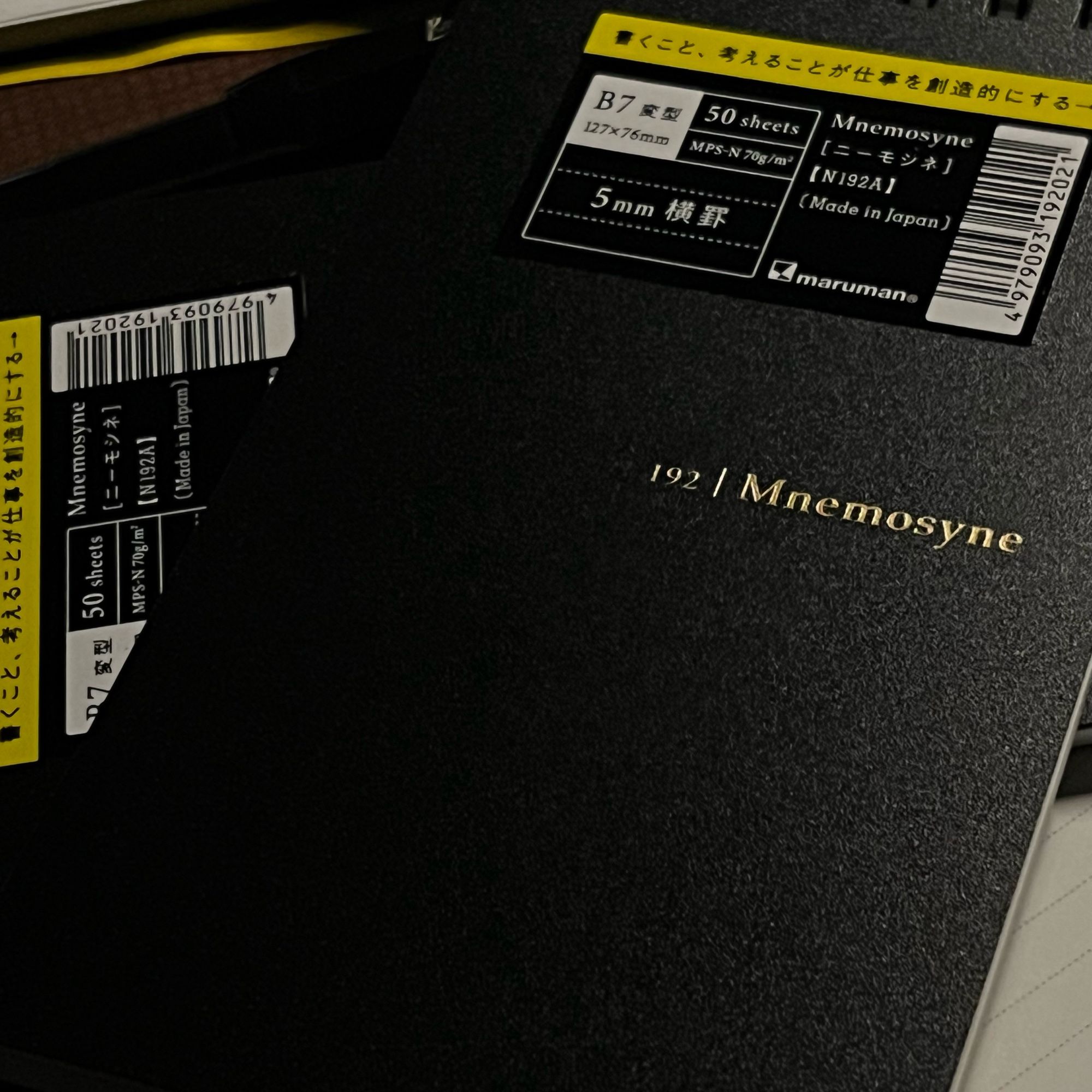 4 of mnemosyne’s modified B7 memo pads tossed messily on a desk with a hard to see black kaweco sport in the top left corner.