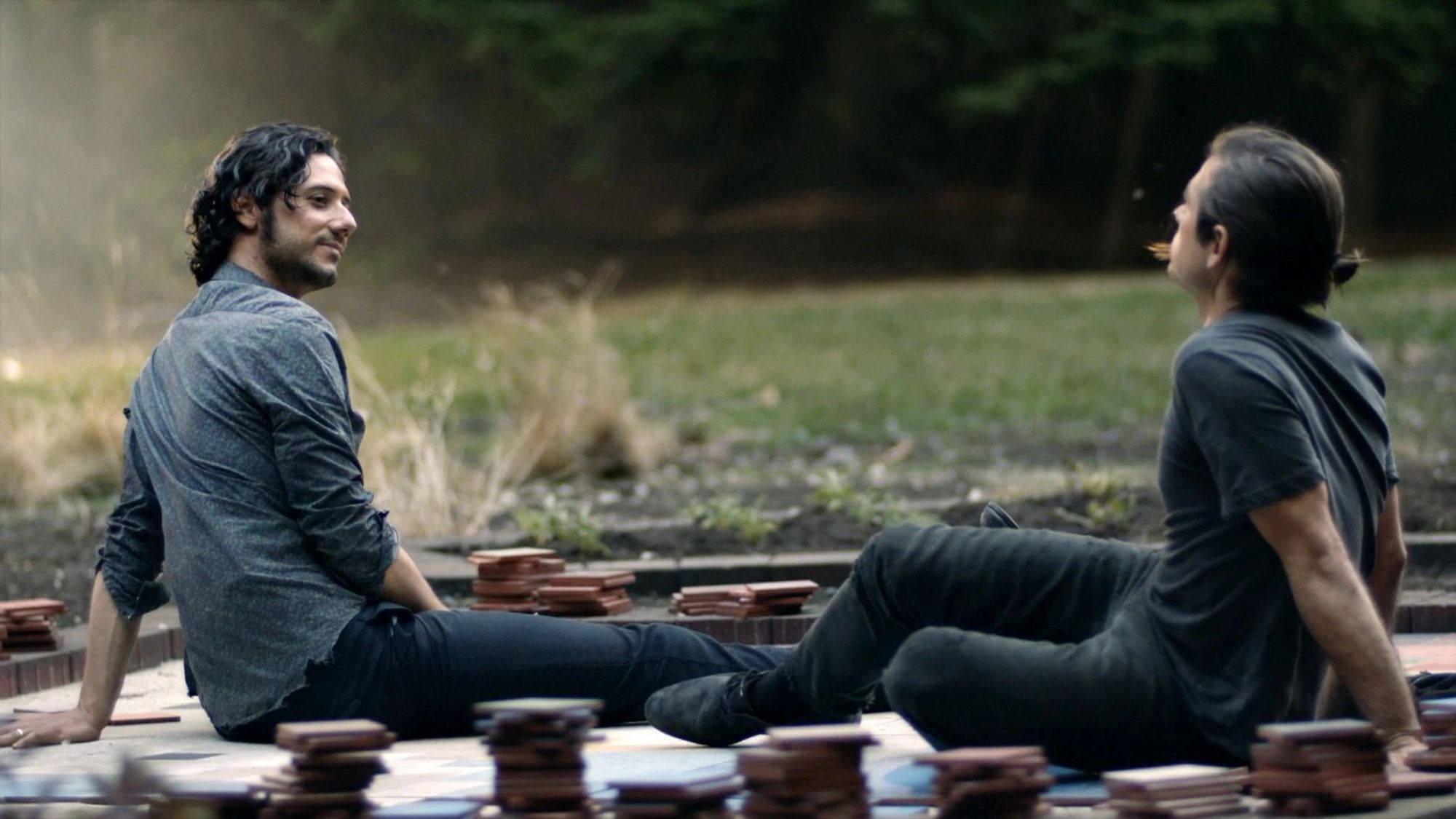 Screengrab of Quentin and Eliot sitting together from "A Life in the Day" from the fifth episode of the third season of The Magicians.