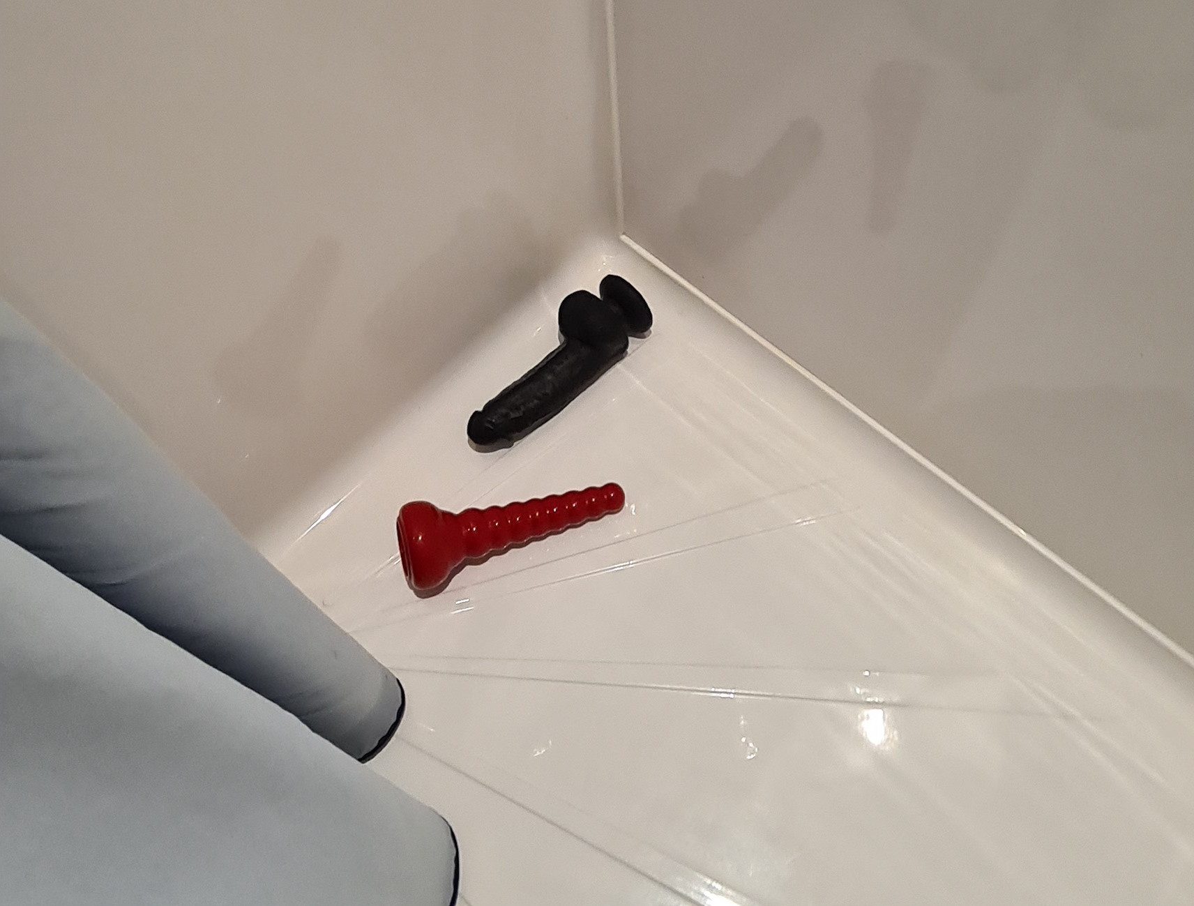 2 dildos in shower tray, 1 red 1 black