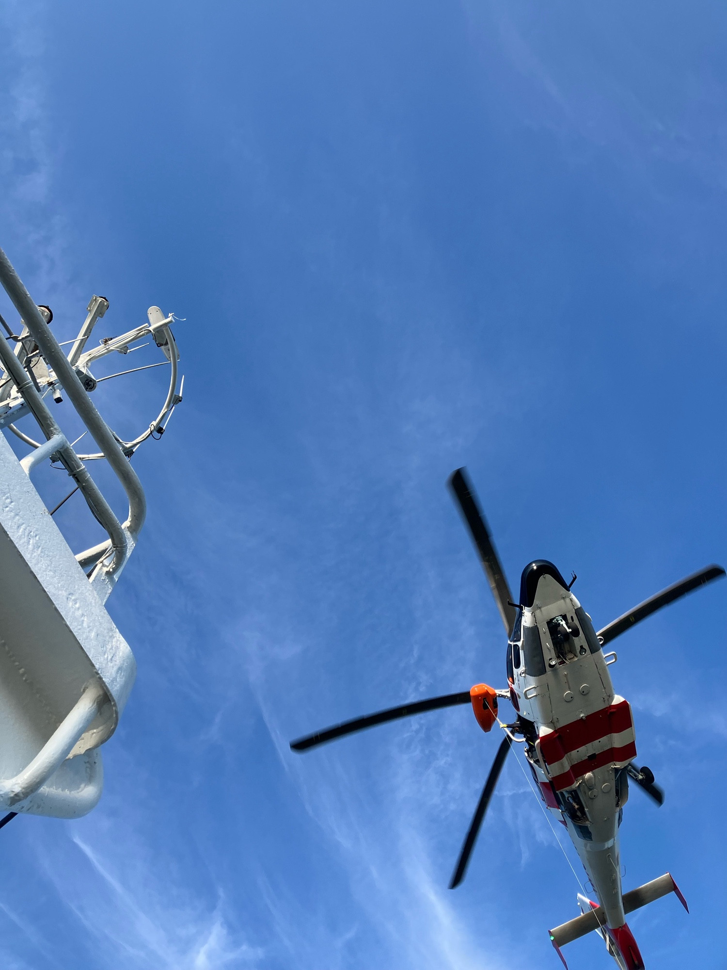 Hubschrauber von unten fotografiert über einem Schiff