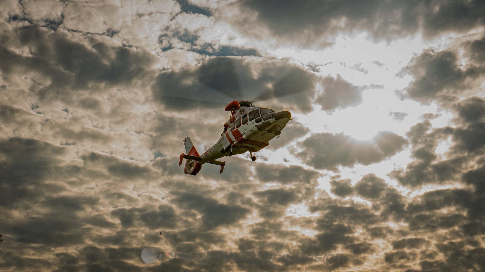 Hubschrauber von unten gegen bewölkten sonnigen Himmel fotografiert.