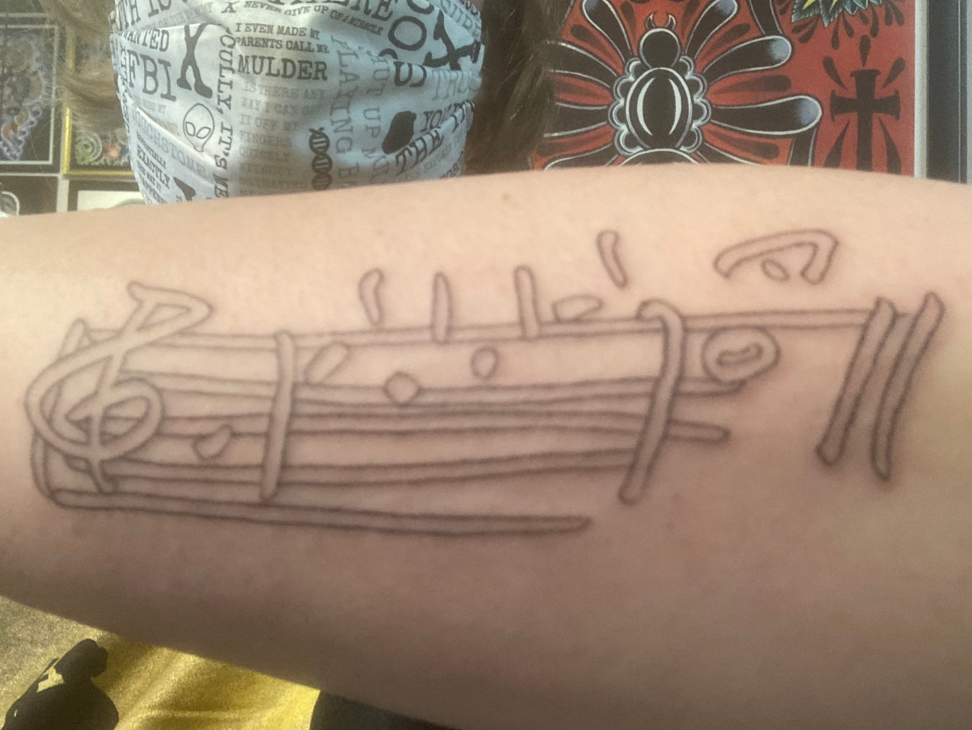 tattoo of the opening line of the X-Files theme, as written out by composer Mark Snow