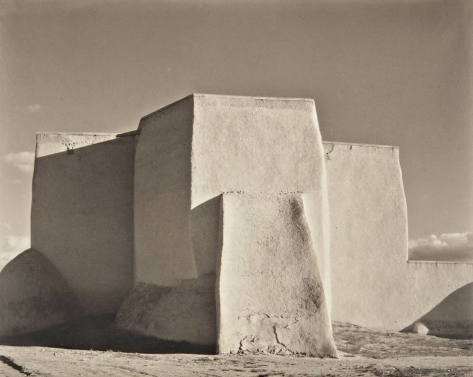 Laura Gilpin, 1930, Ranchos de Taos Church — the beautiful, spare adobe church in Ranchos de Taos, NM, in sepiatone.