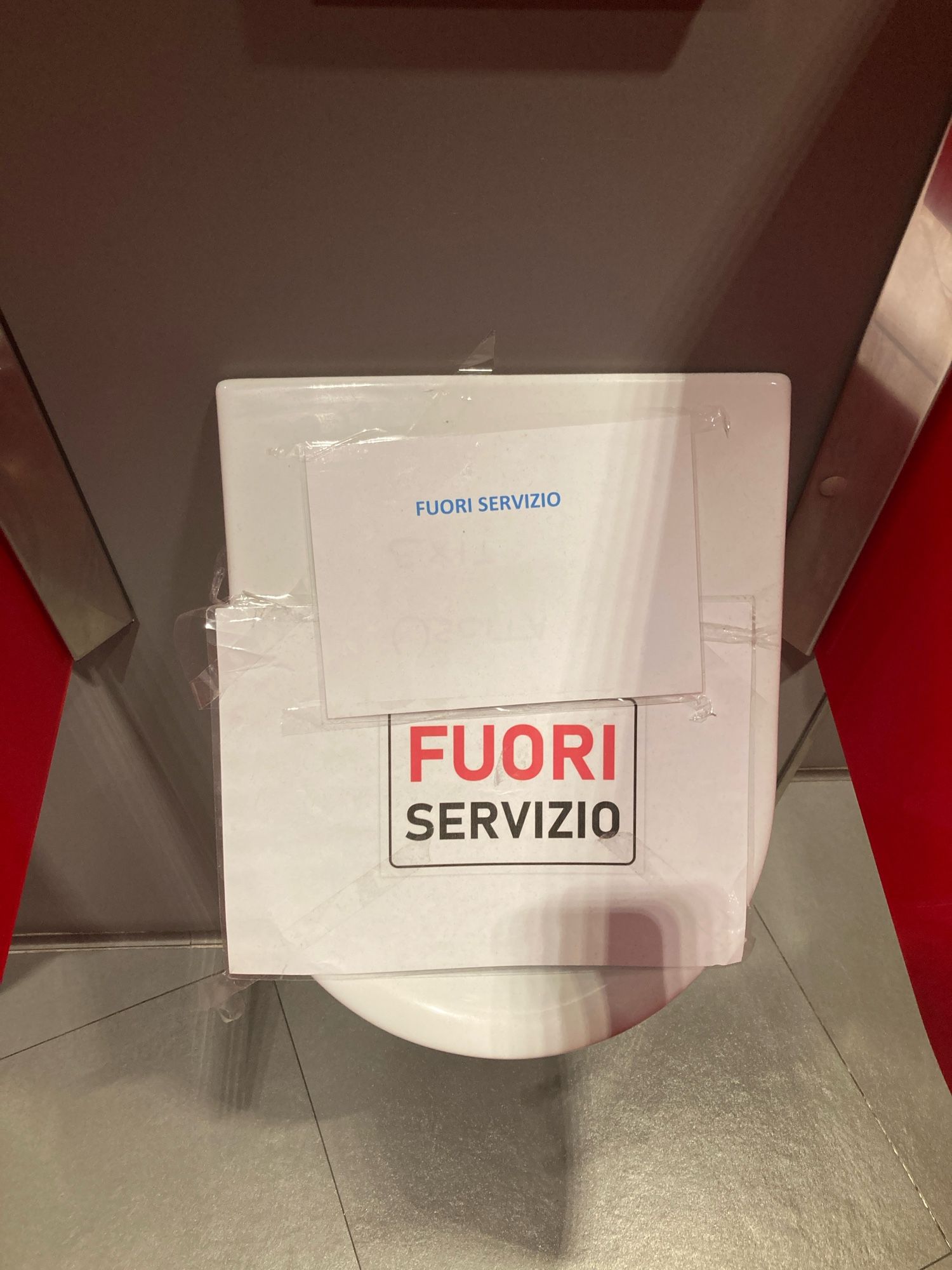 ein pissoir mit zwei “fuori servizio”-schilder