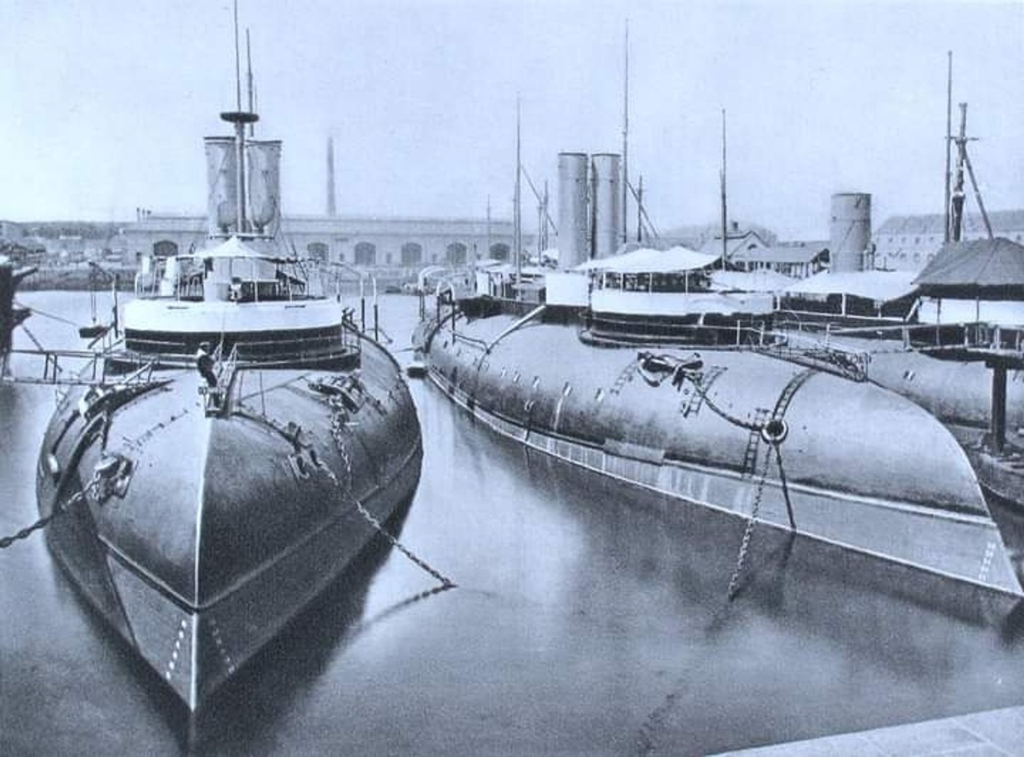 Two French Ironclads of the Bélier class, moor d up next to each other in a military port. They look like they are upside down. Being French, they may well be.