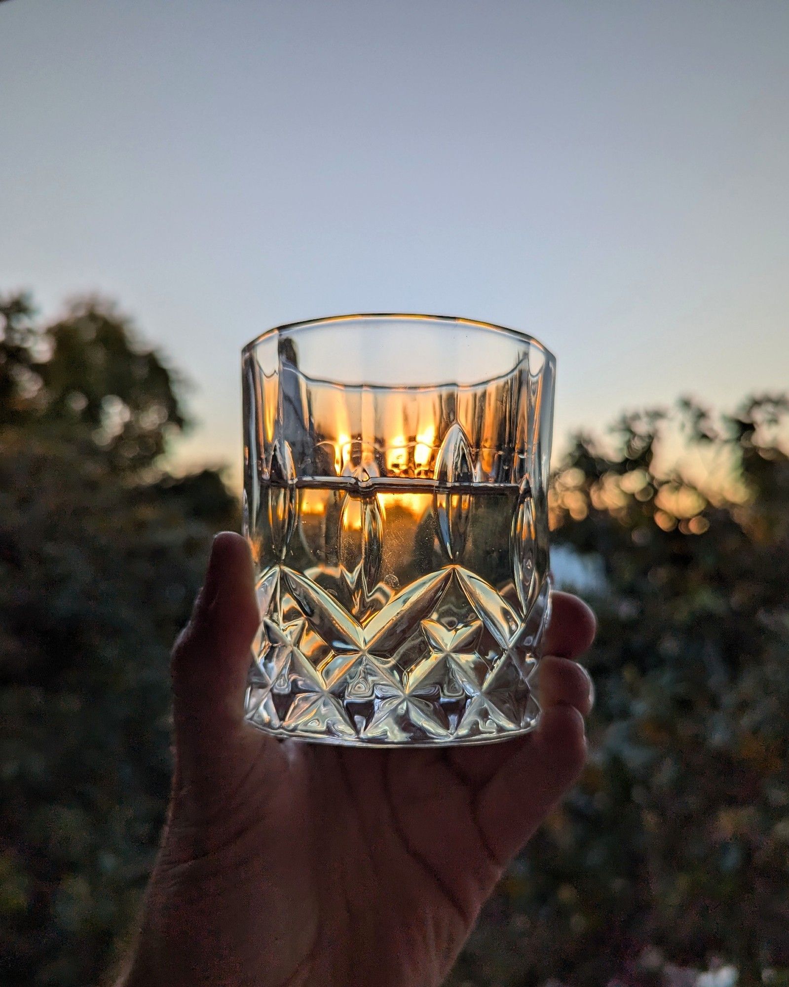 A glass of white wine against the sunset.