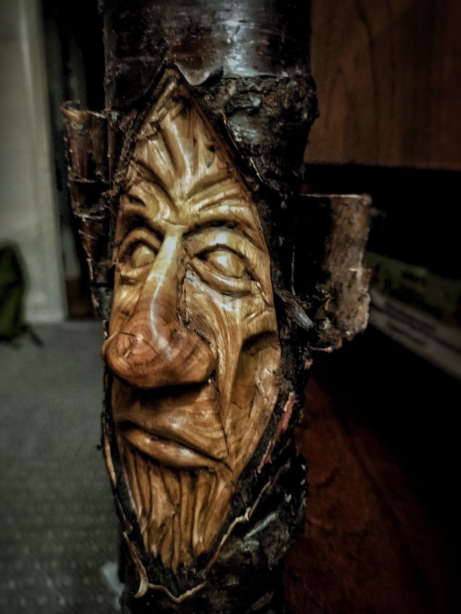 Gormless face carved into a very swirly grained cherry branch. Stylised wood spirit