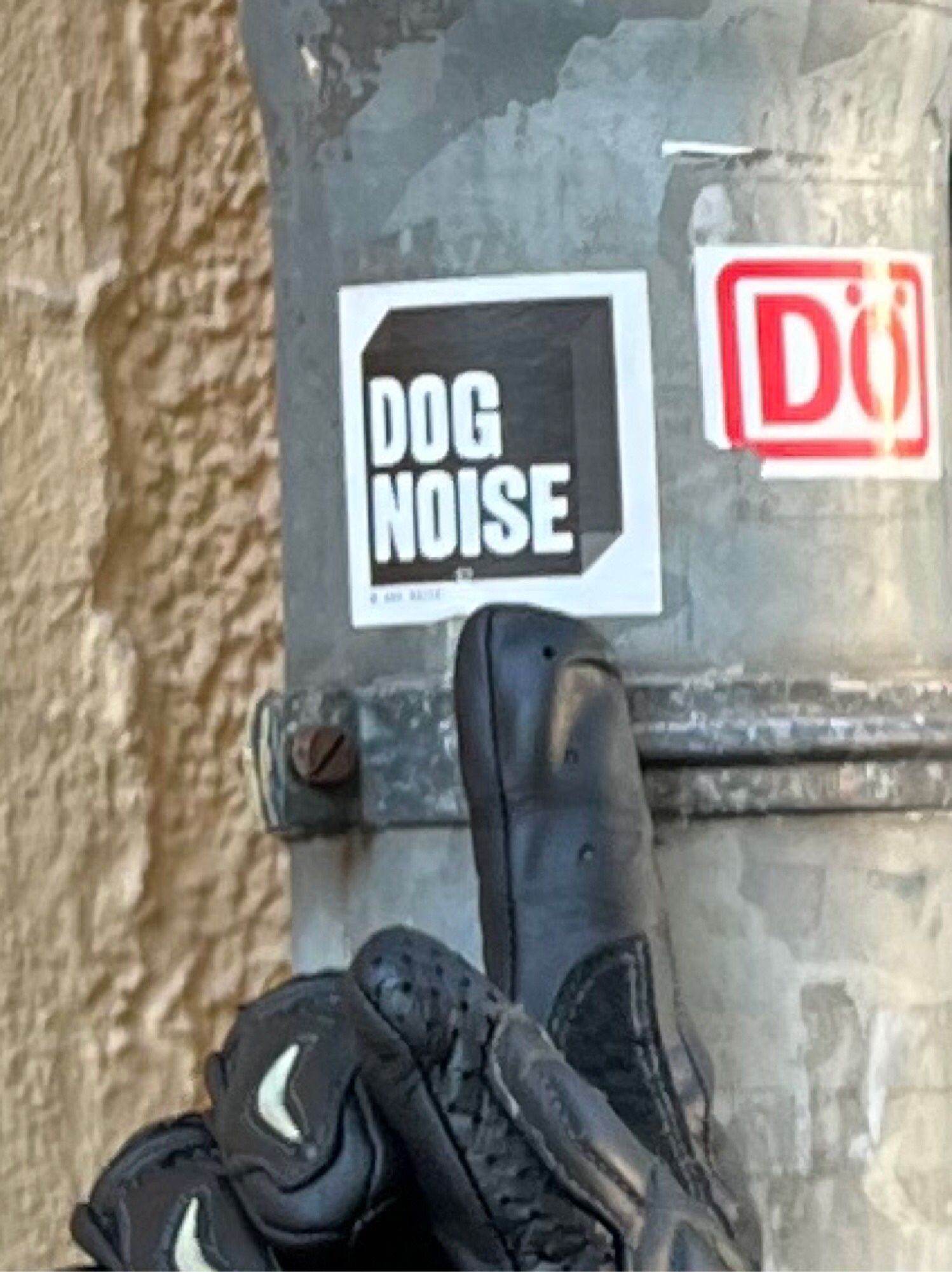 A zoomed in view of the sticker.  It reads DOG NOISE.