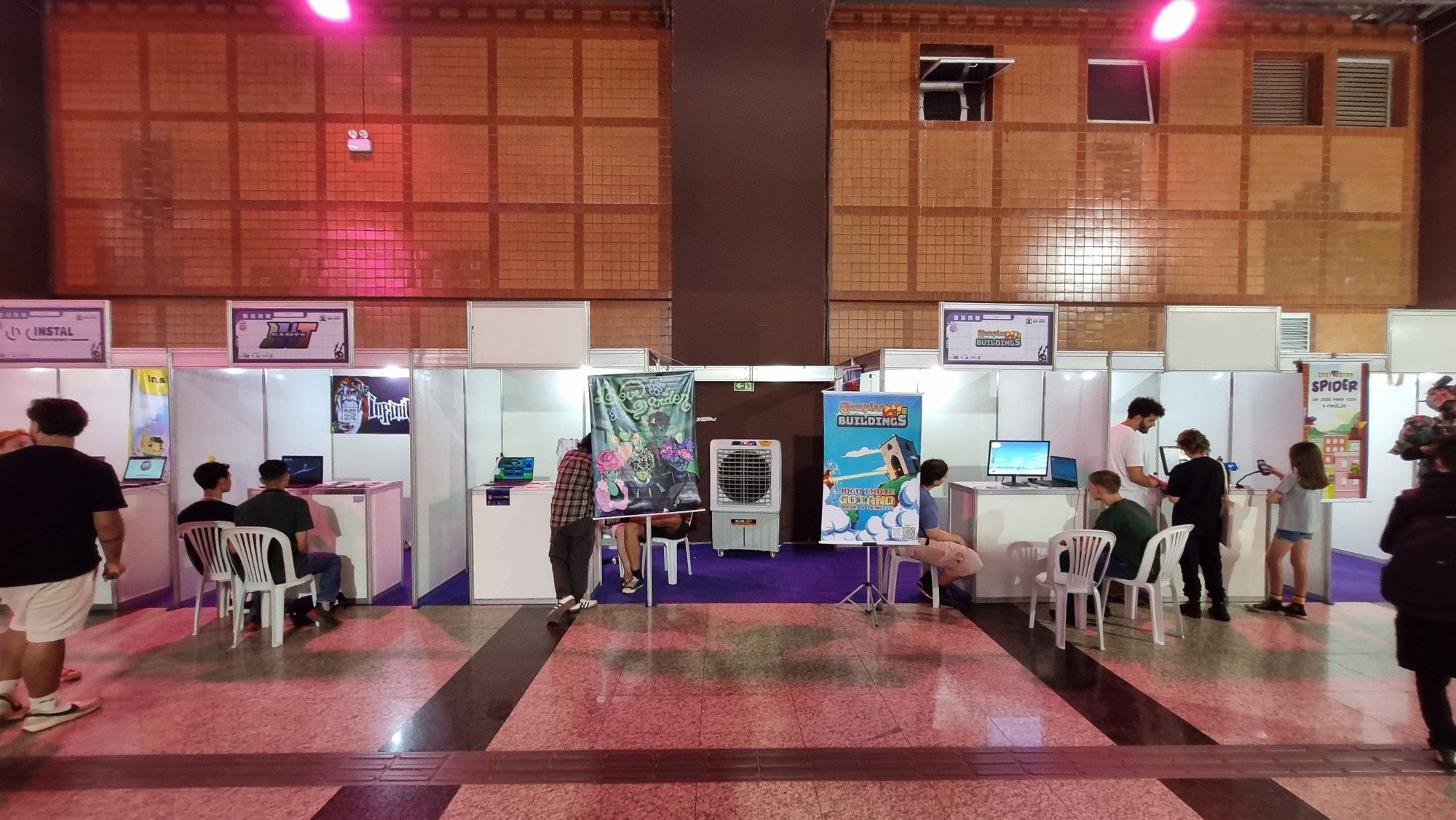 Já dentro da área paga do evento, onde tinha o palco, tinha stands assim