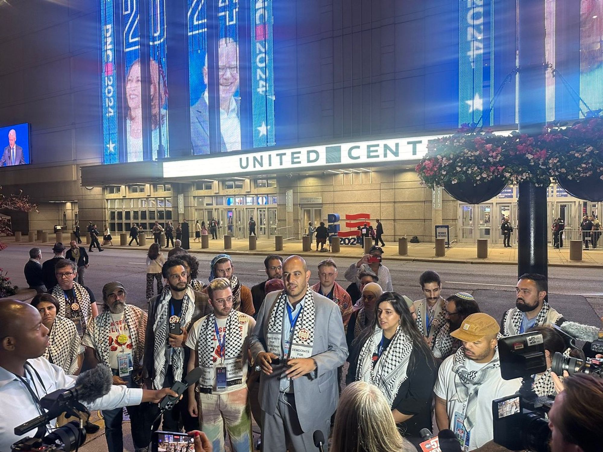 A small group stands with press outside the United Center with bright lights and images of Kamala and Tim Walz.
Under the lights of Kamala Harris & Tim Walz, Uncommitted Movement officially announces that the DNC has said *No* to welcoming a Palestinian voice to the stage:
https://x.com/prem_thakker/status/1826435916757409937


https://x.com/prem_thakker/status/1826435916757409937