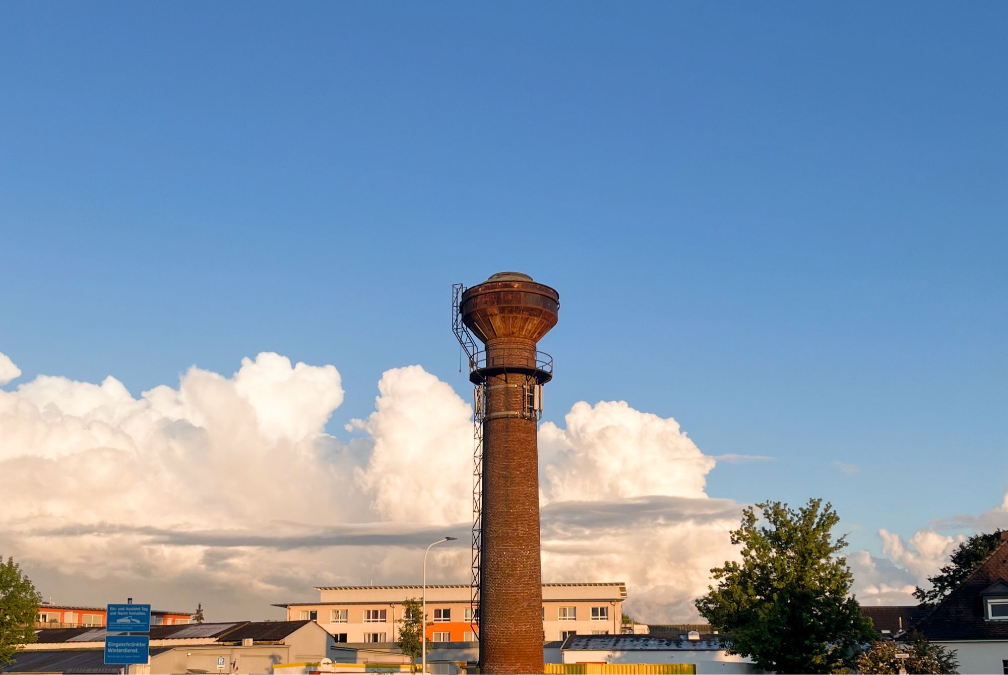 Alter Schornstein vor blauem Himmel mit großer Wolke