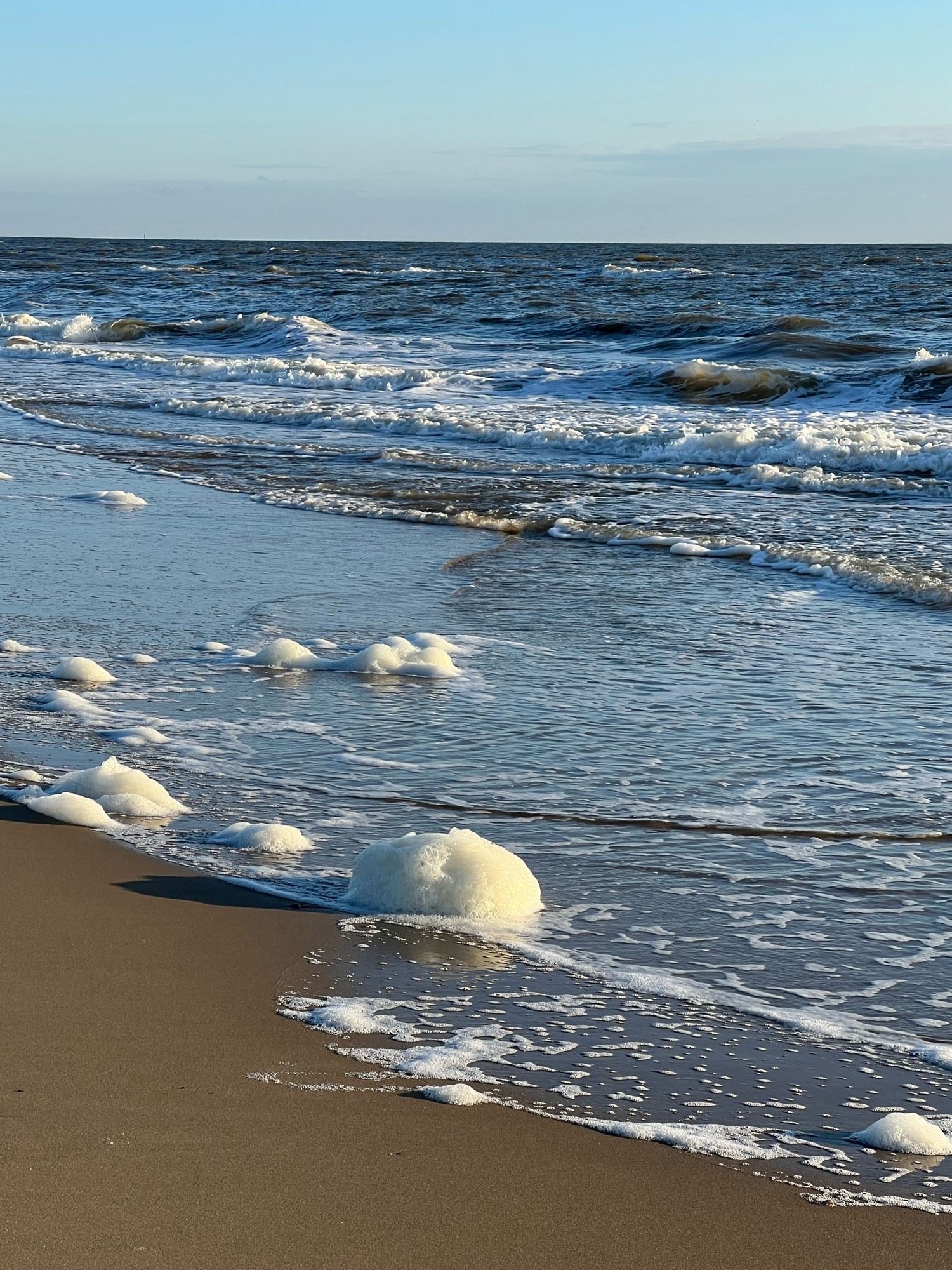 Golven rollen het strand op