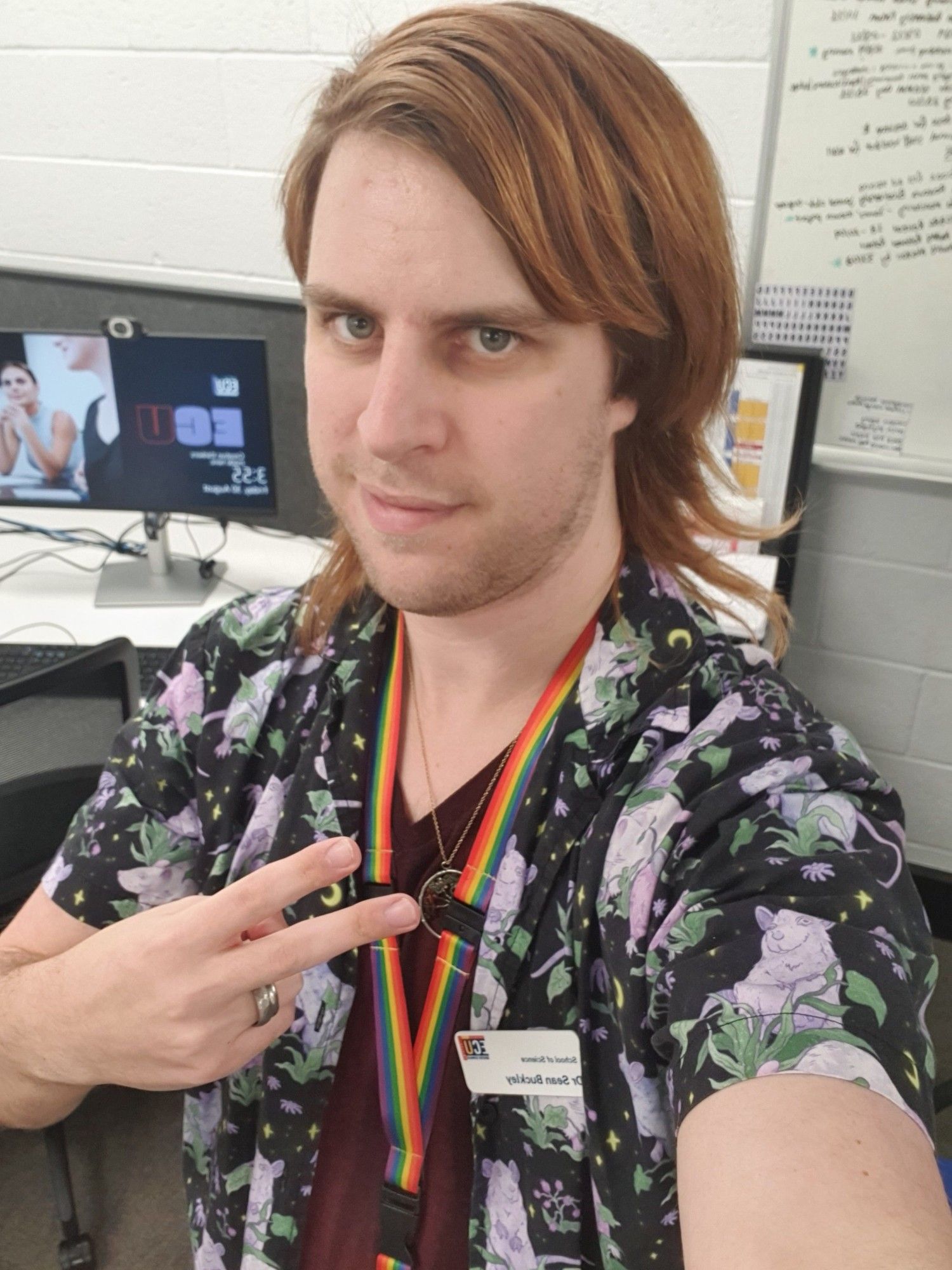 A selfie of me wearing a collared shirt with a purple ghost rat print.