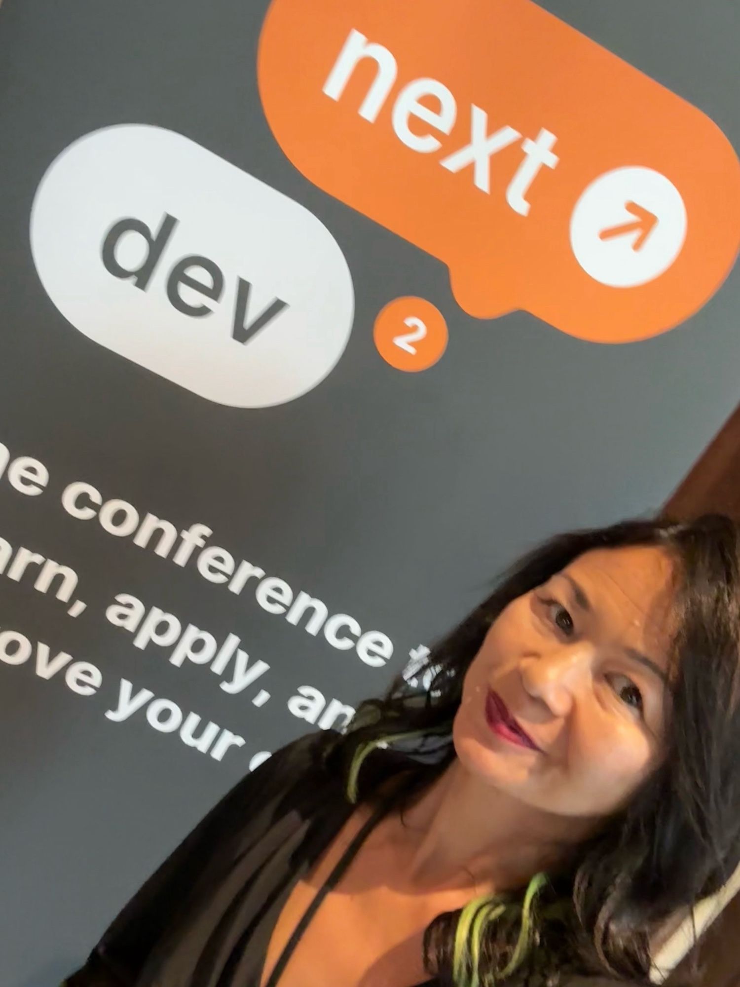 Selfie of me in front of the Dev2Next tech conference banner in Lonetree, CO